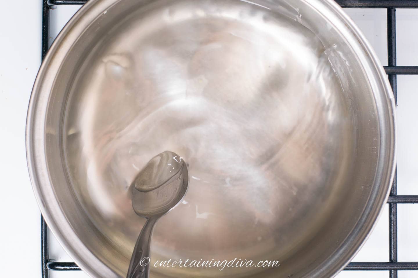 sugar and water being mixed in a saucepan