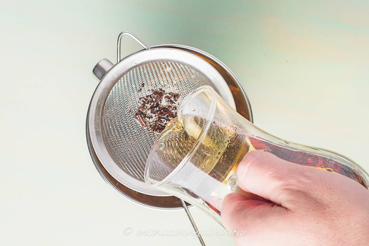 Tea leaves being strained from the cold brewed tea