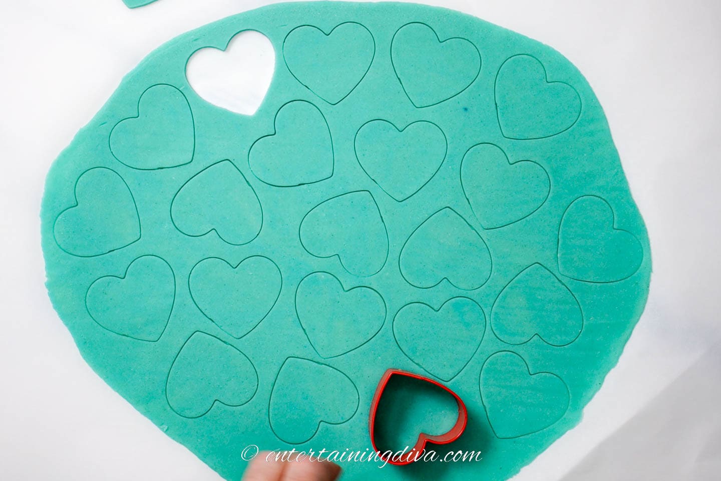 Hearts being cut out of rolled out cookie dough