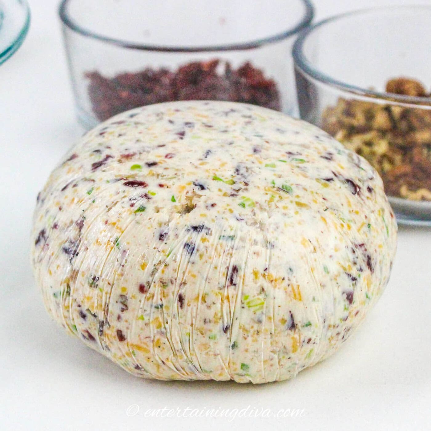 cheese mixture in a ball wrapped with plastic wrap