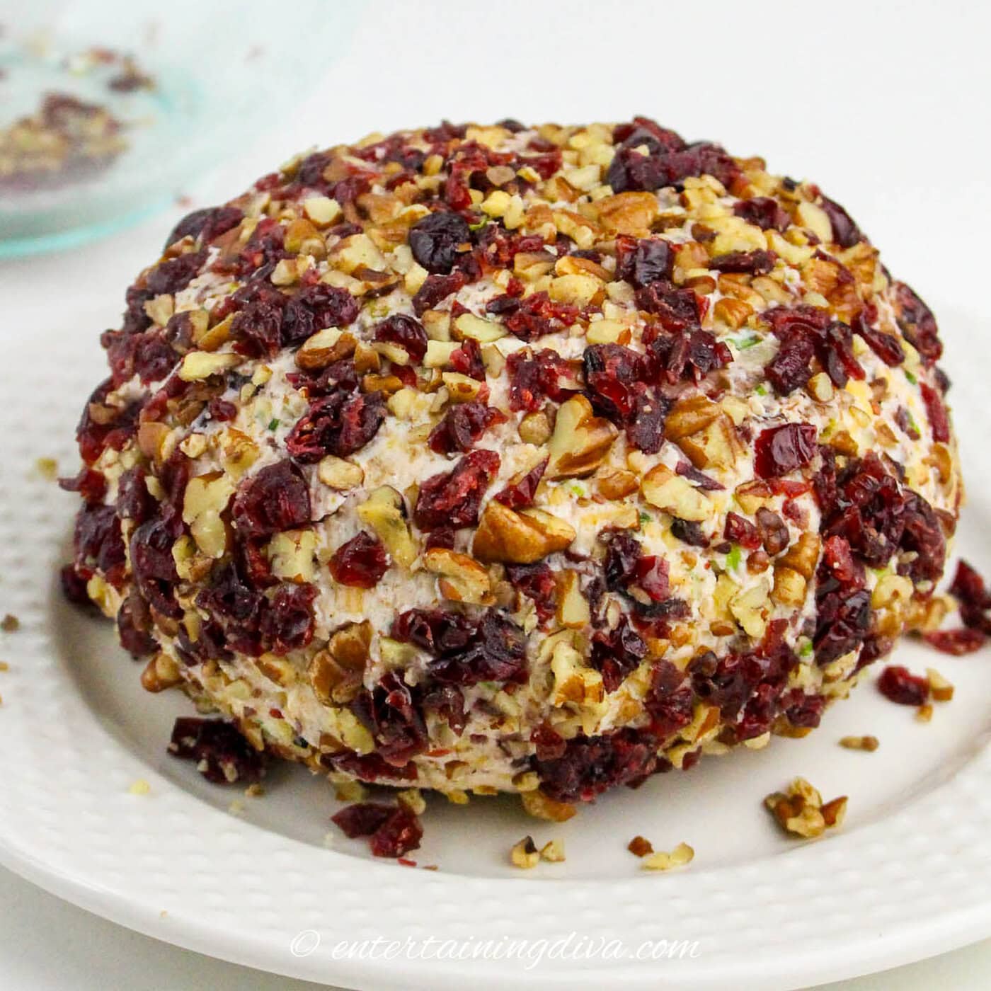 cranberry pecan cheese ball coated with chopped pecans and cranberries