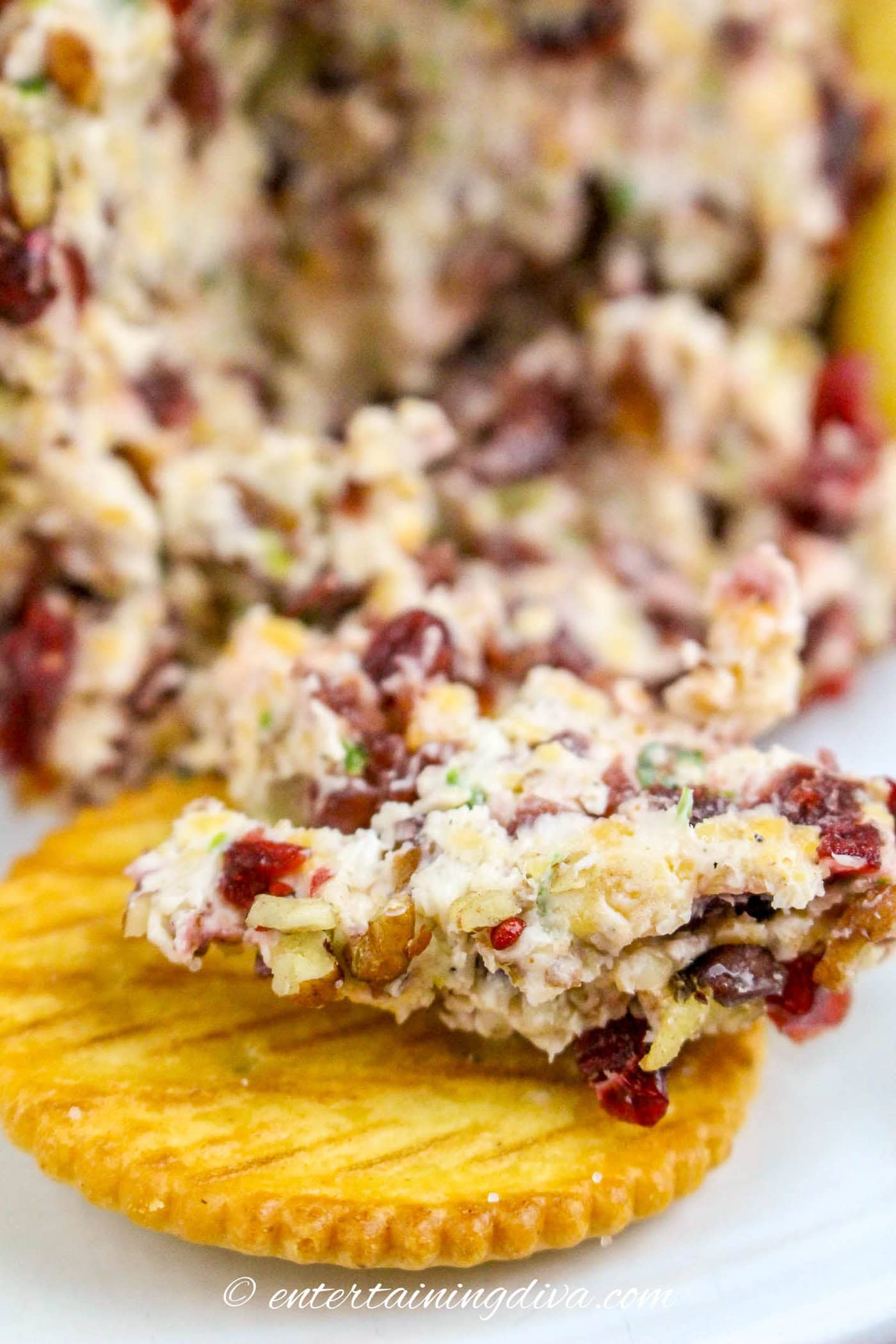 cranberry pecan cheese ball on a cracker