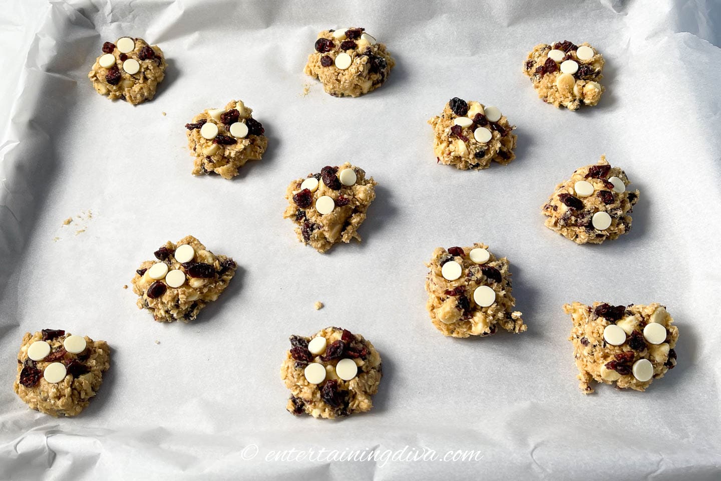 cranberry white chocolate oatmeal cookies with extra white chocolate chips and cranberries on top