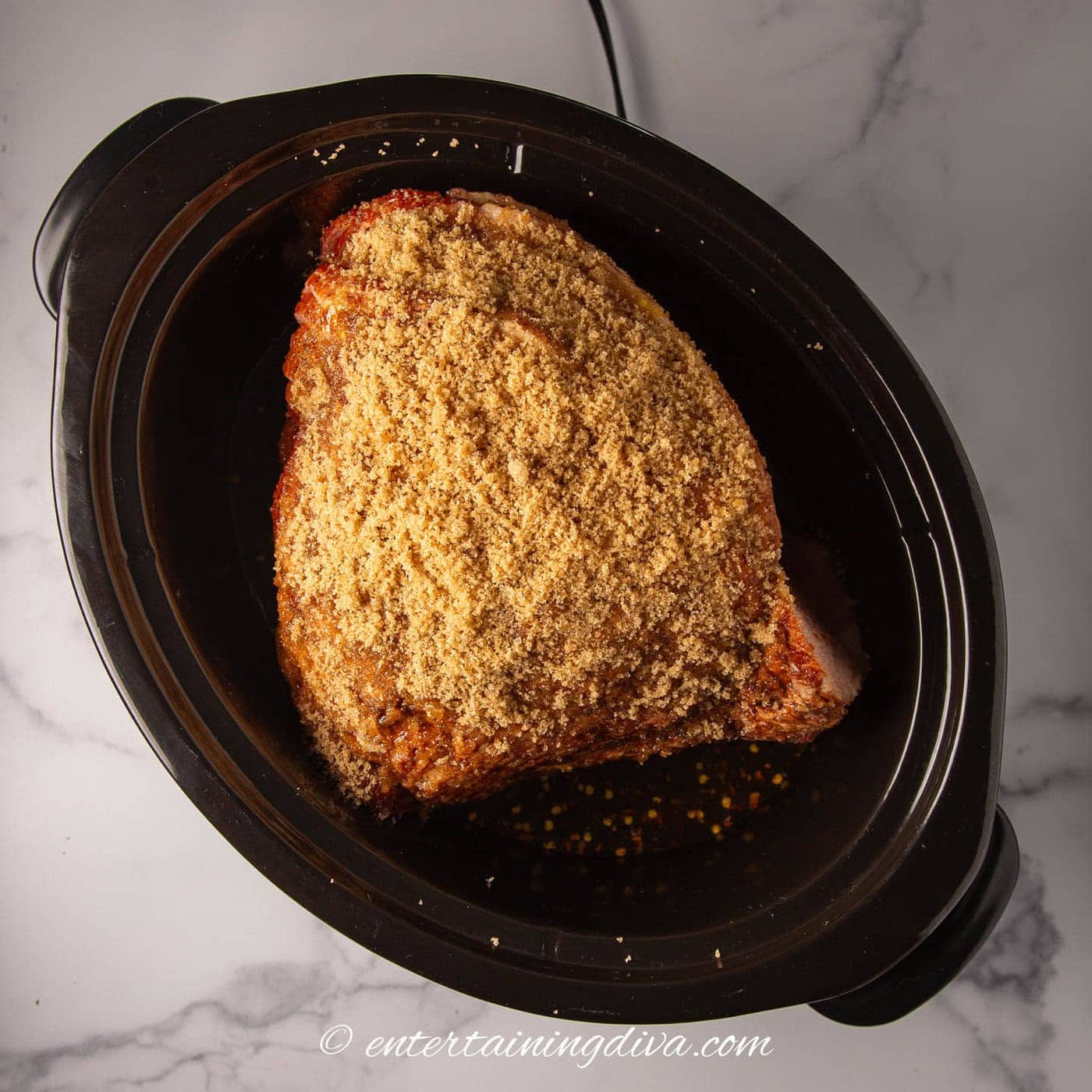 brown sugar on top of a spiral ham in a crock pot