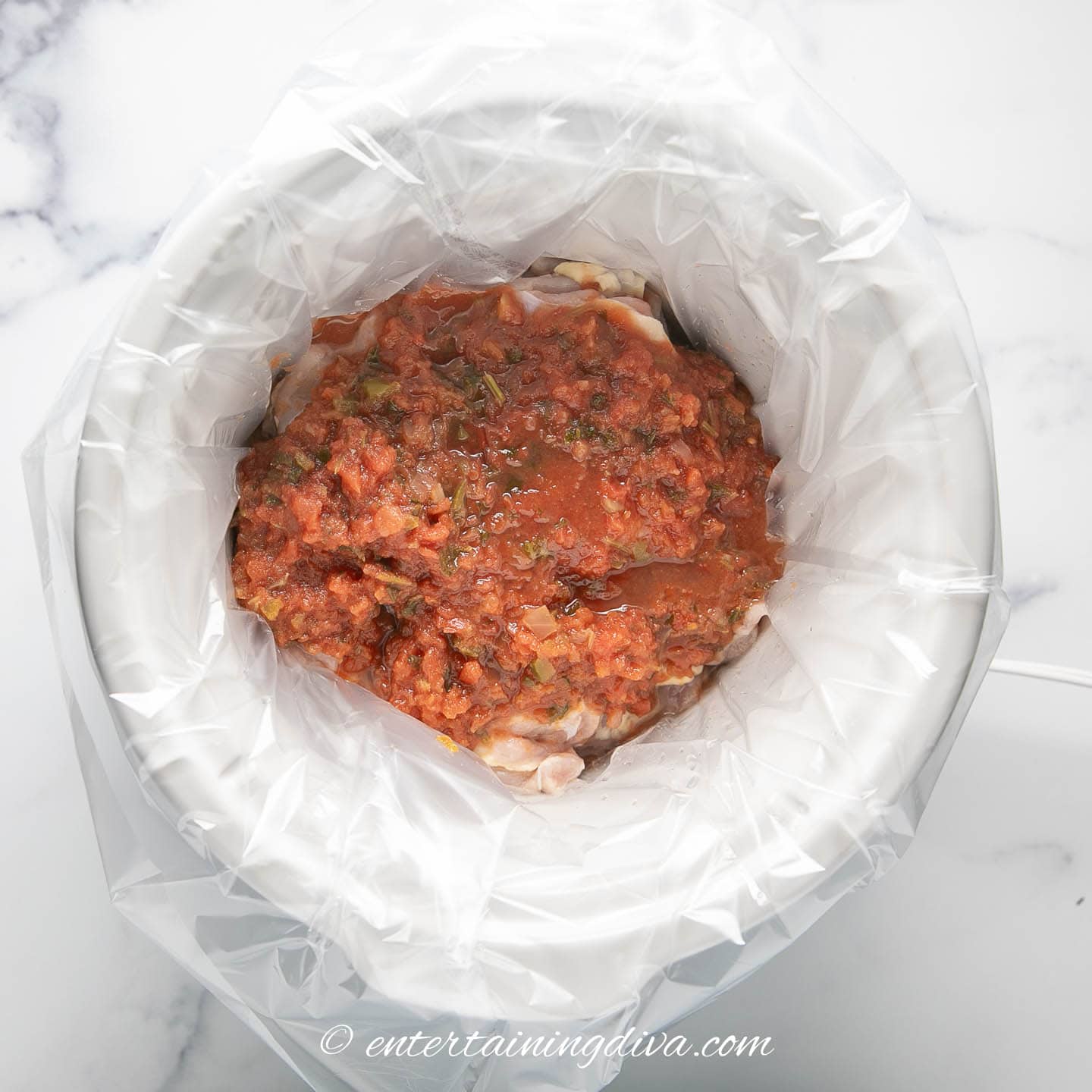 crock pot with chicken and salsa in it