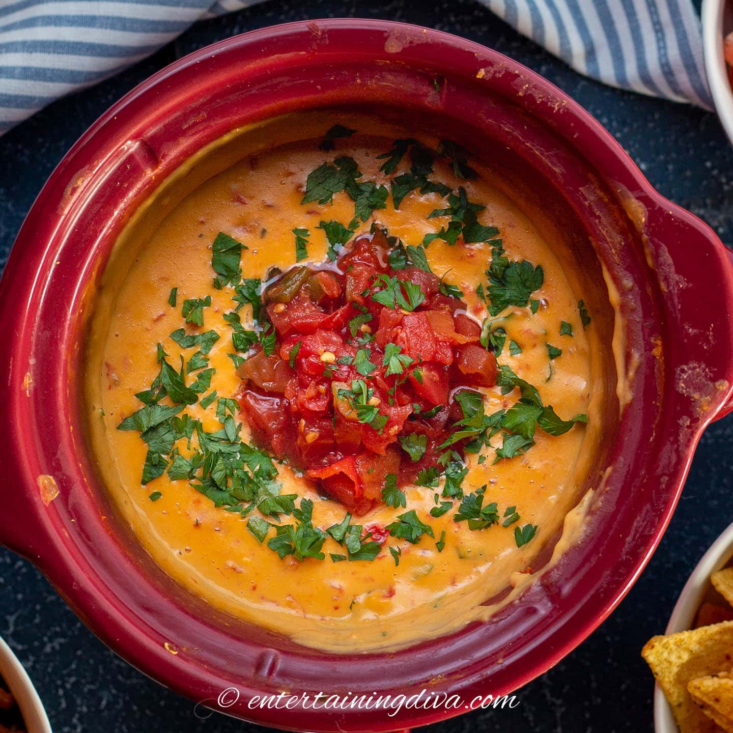 Crockpot Velveeta Rotel cheese dip with chopped tomatoes and fresh cilantro