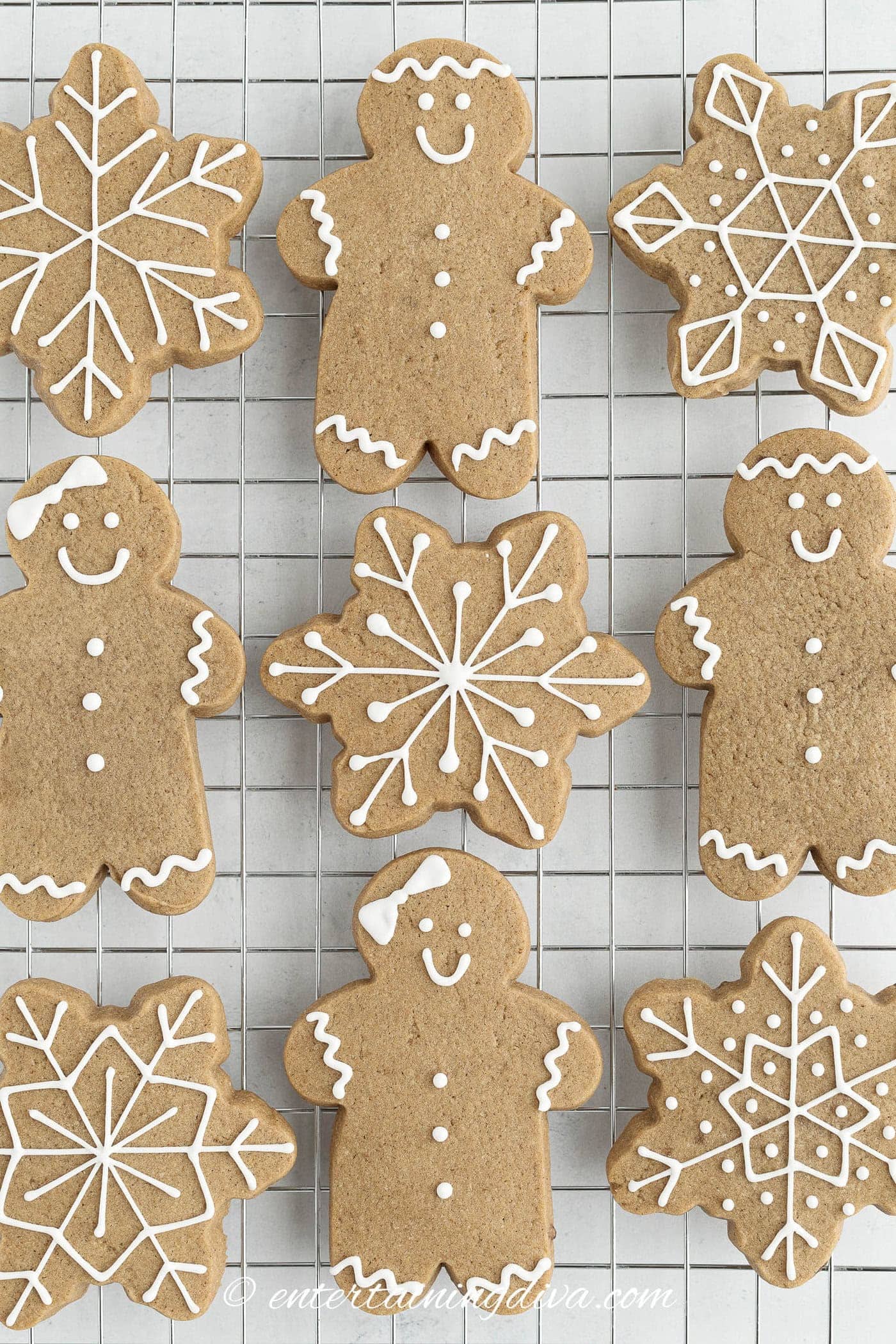 decorated cut out gingerbread men, women and snowflakes on a wire cooling rack