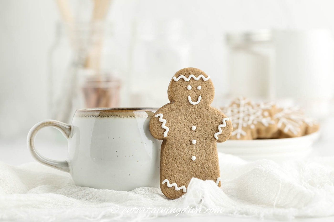 a cut out gingerbread man standing up in front of a coffee mug