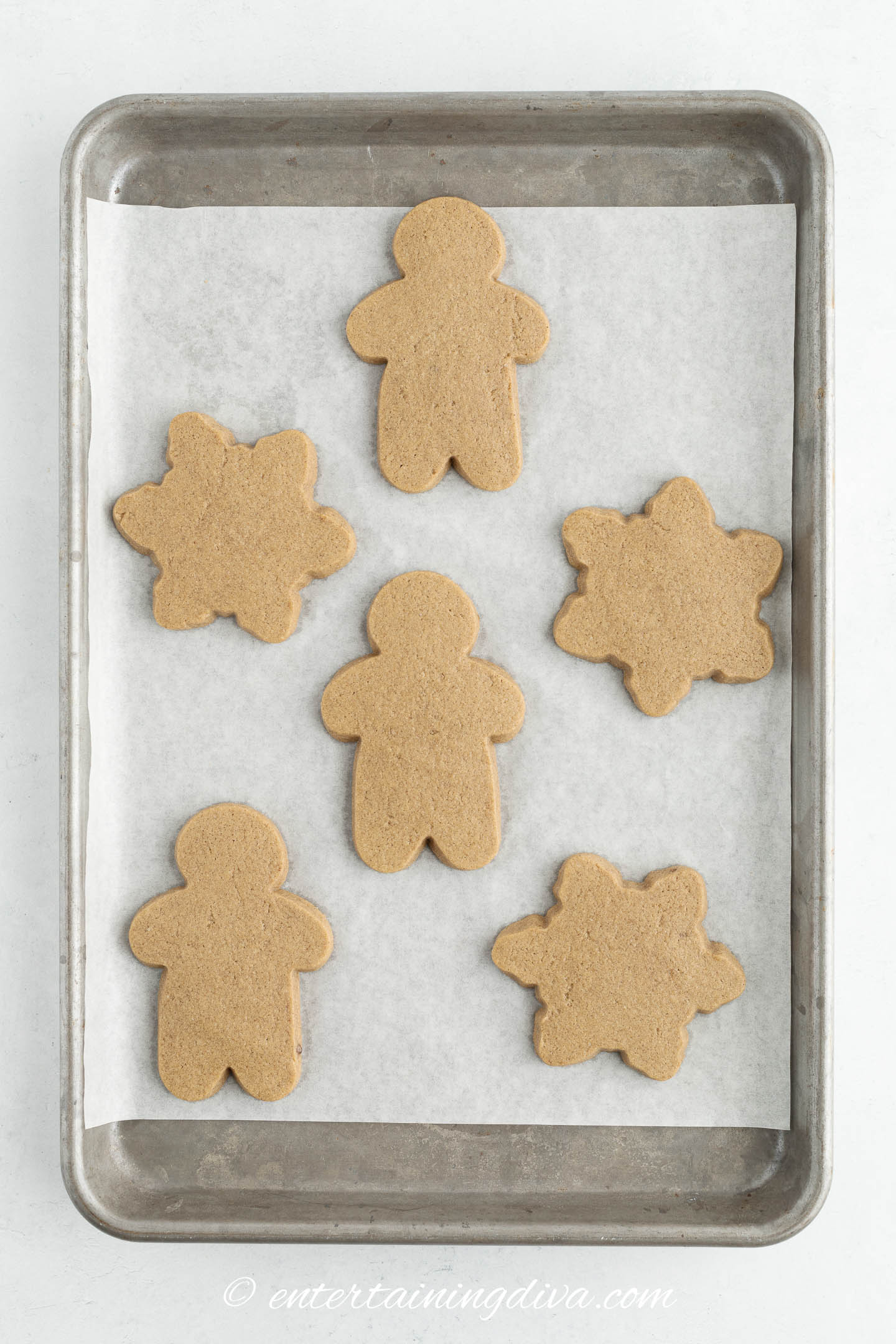 gingerbread men and stars on a cookie sheet after baking