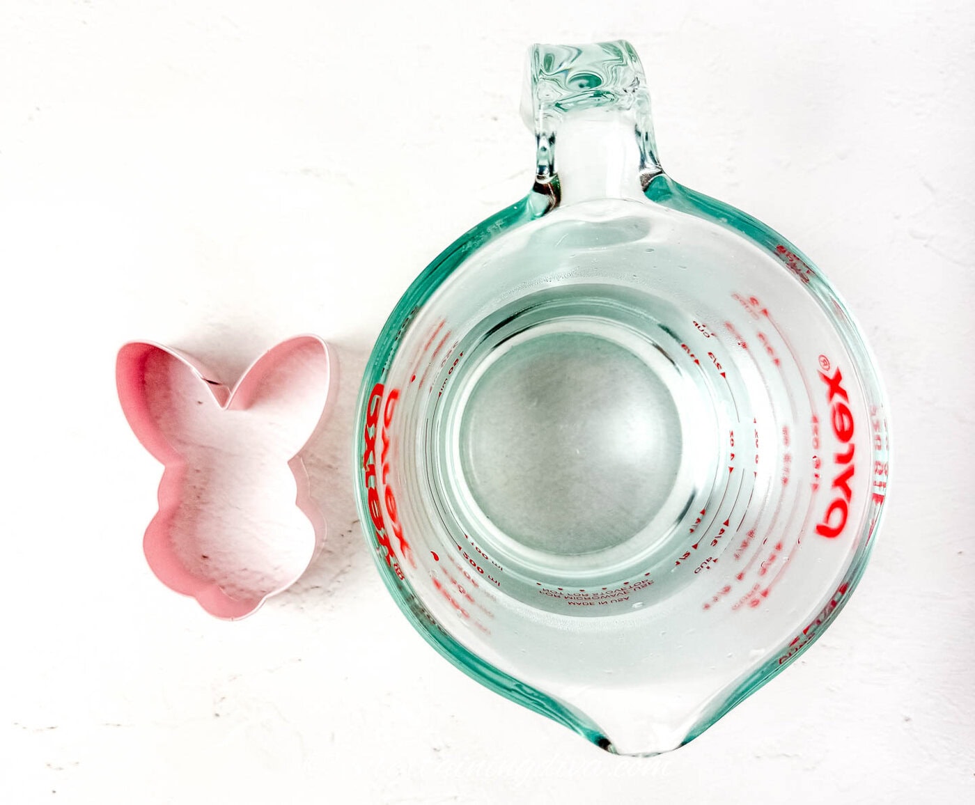 A bowl of hot water with an Easter bunny cookie cutter beside it