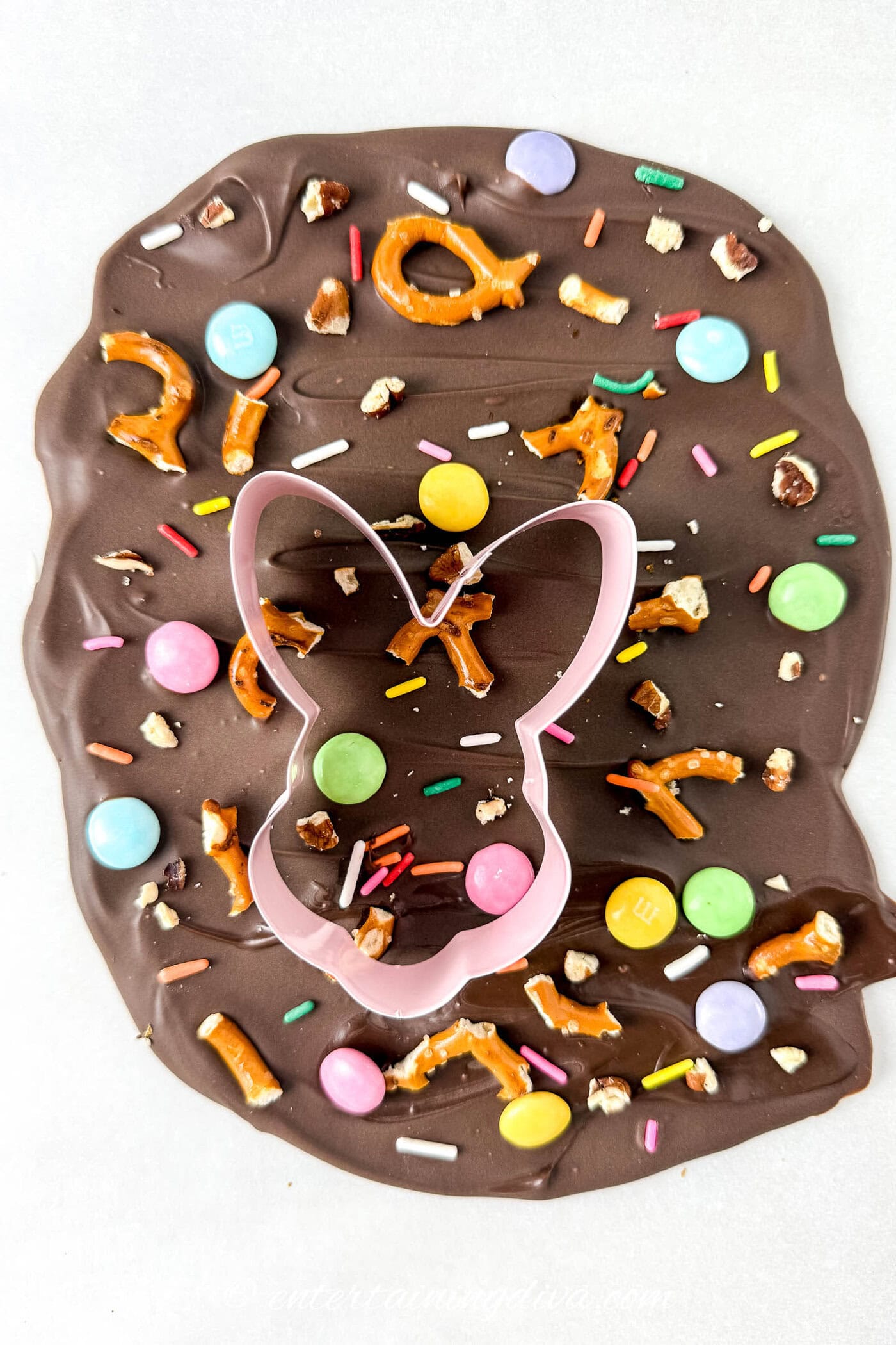 A bunny cookie cutter on milk chocolate Easter bark