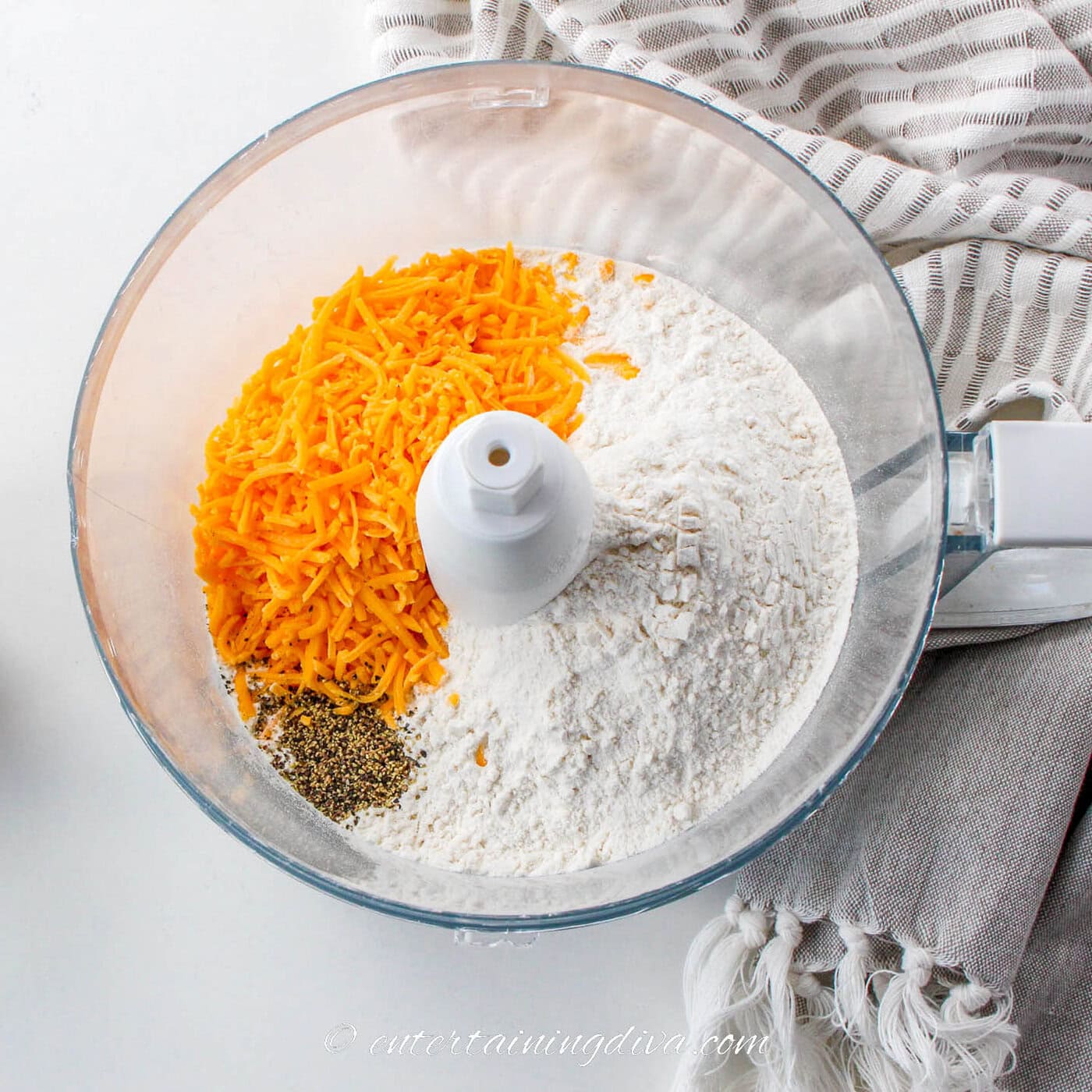 shredded cheddar cheese, flour and pepper in a food processor
