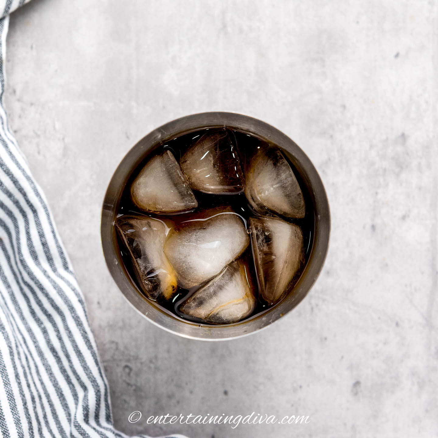 overhead of espresso martini ingredients in a cocktail shaker with ice