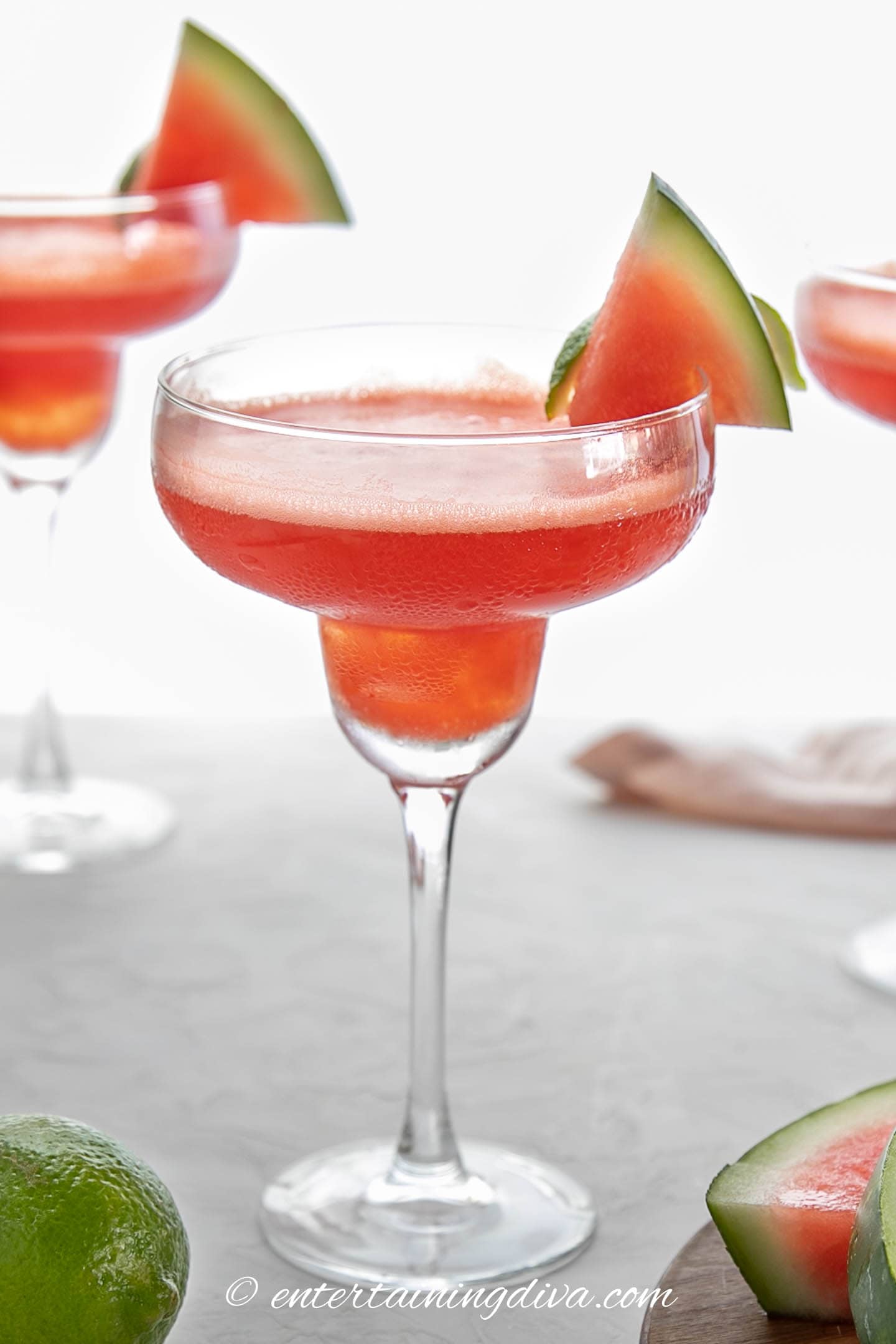 homemade frozen watermelon margarita in a glass garnished with a slice of watermelon