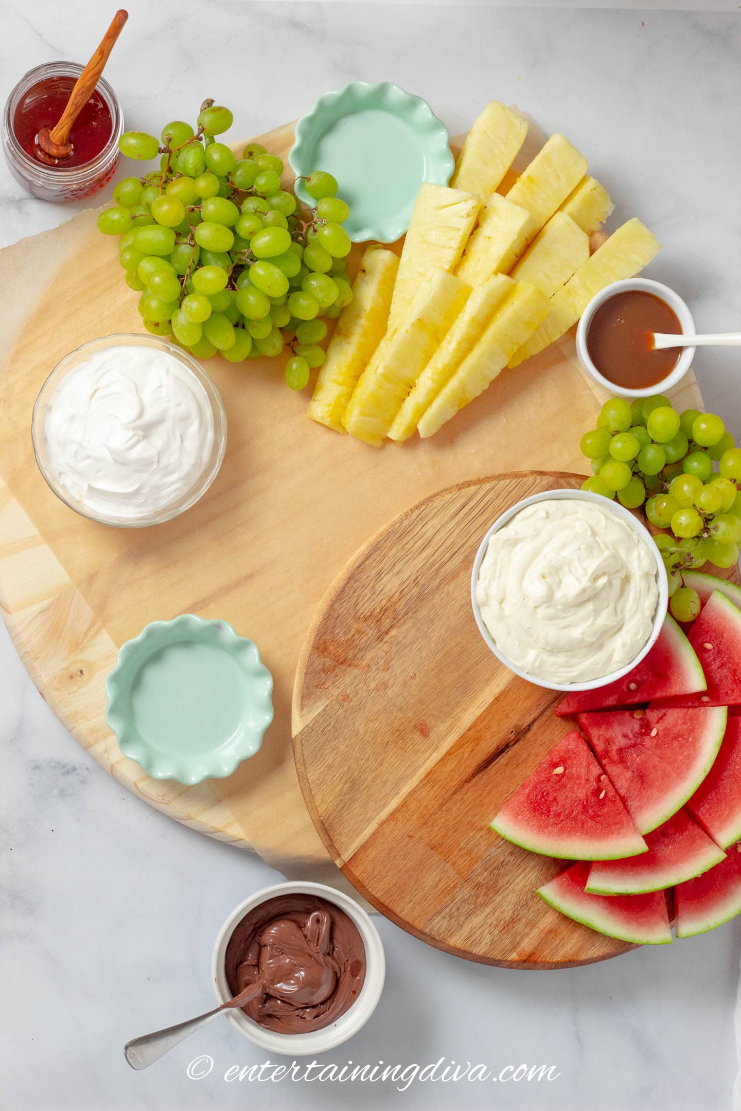 charcuterie board with pineapple, watermelon, grapes and dips