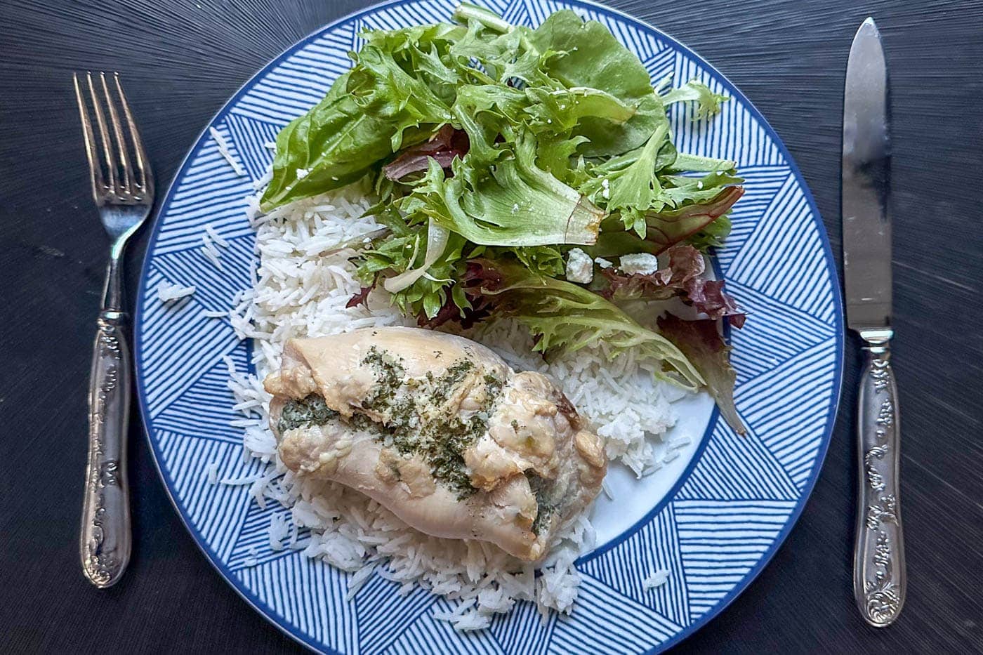 garlic butter chicken roll up on a plate with salad