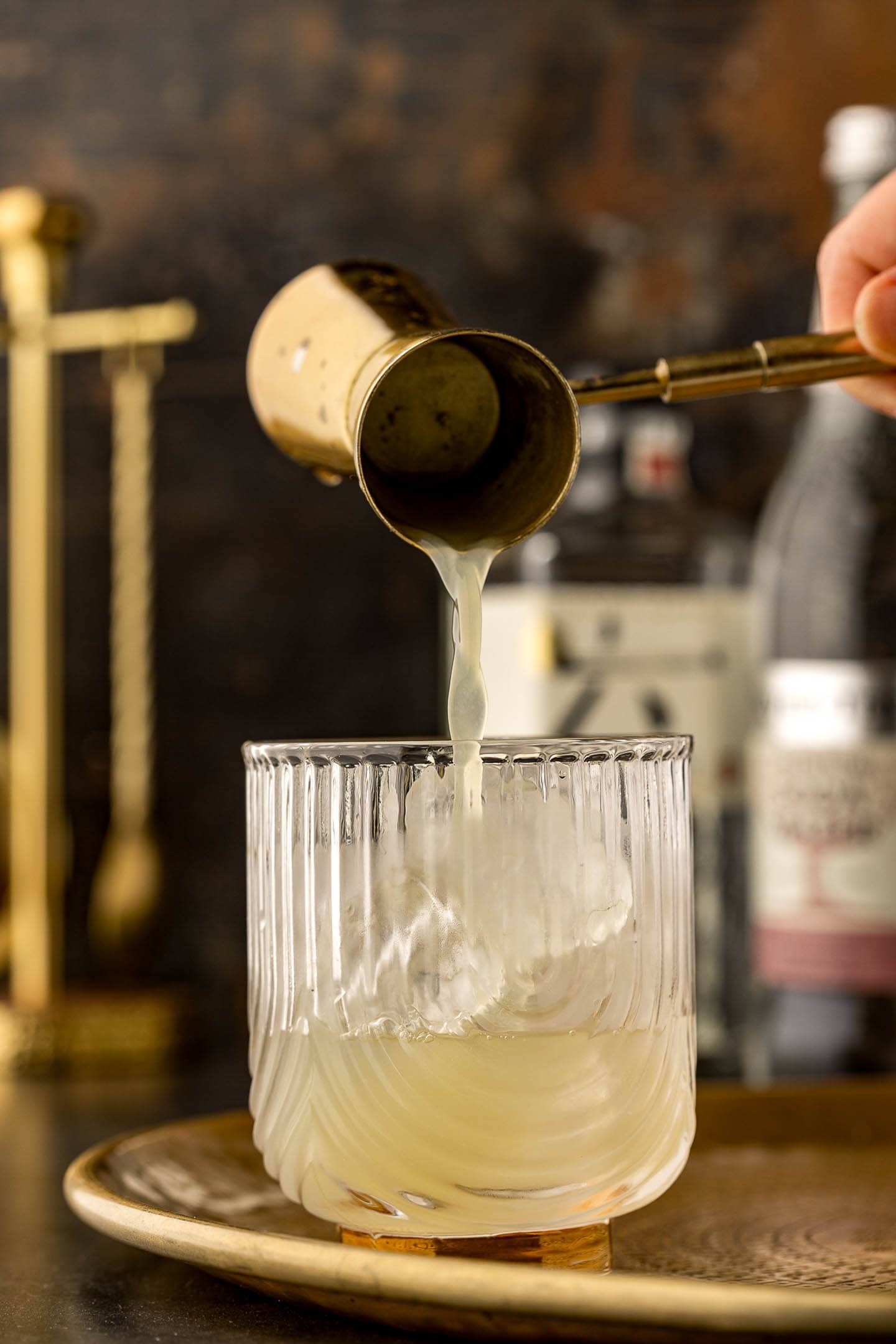 Lime juice being poured into a gin rickey