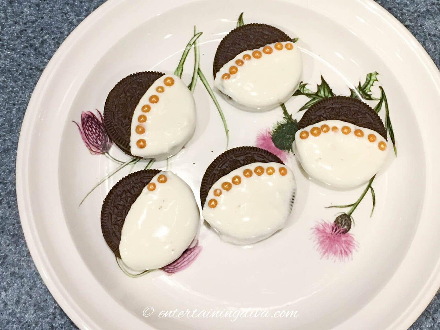 Oreo cookies dipped in white chocolate with gold sugar balls