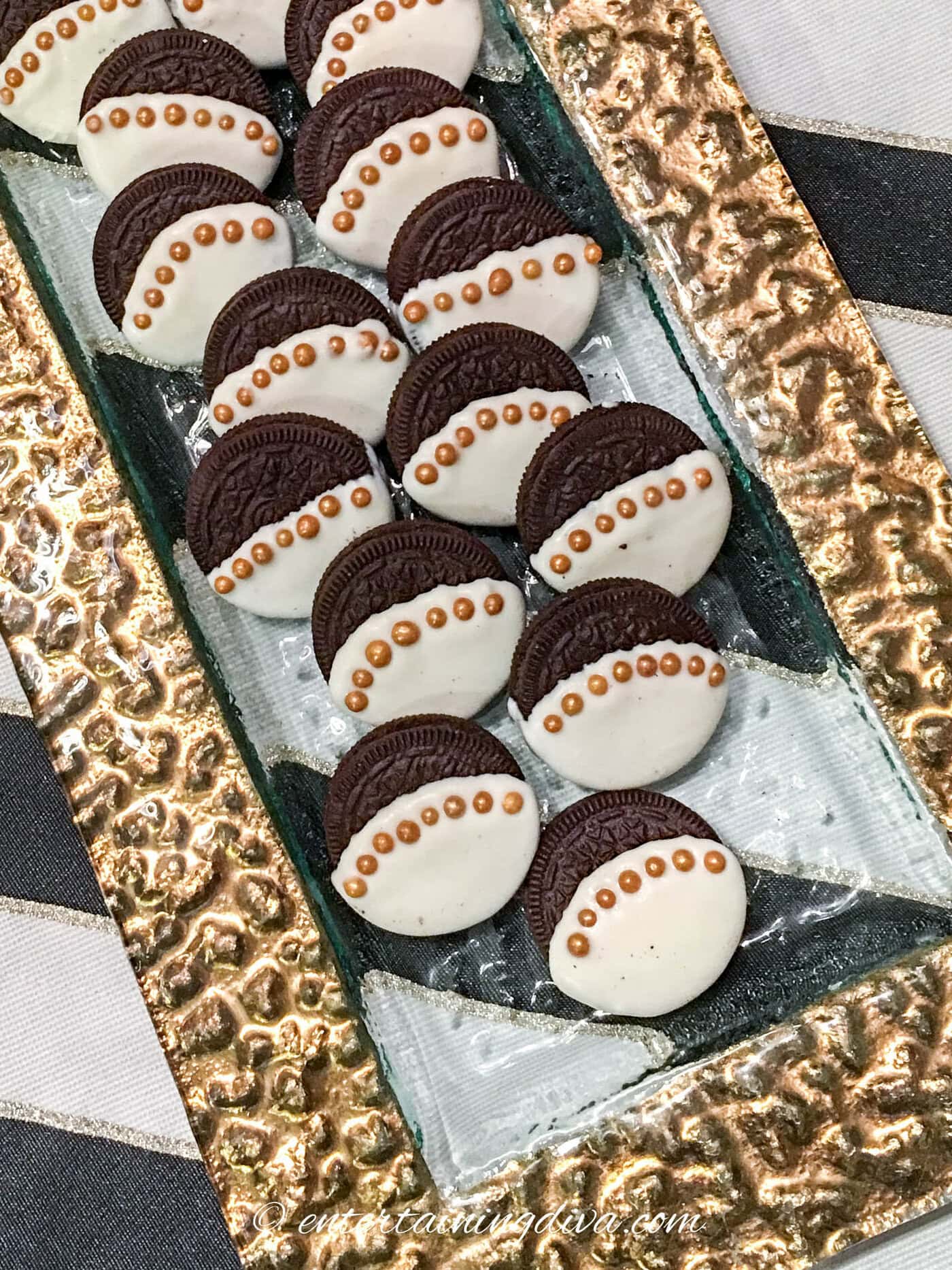 Oreo cookies dipped in white chocolate trimmed with gold sugar balls