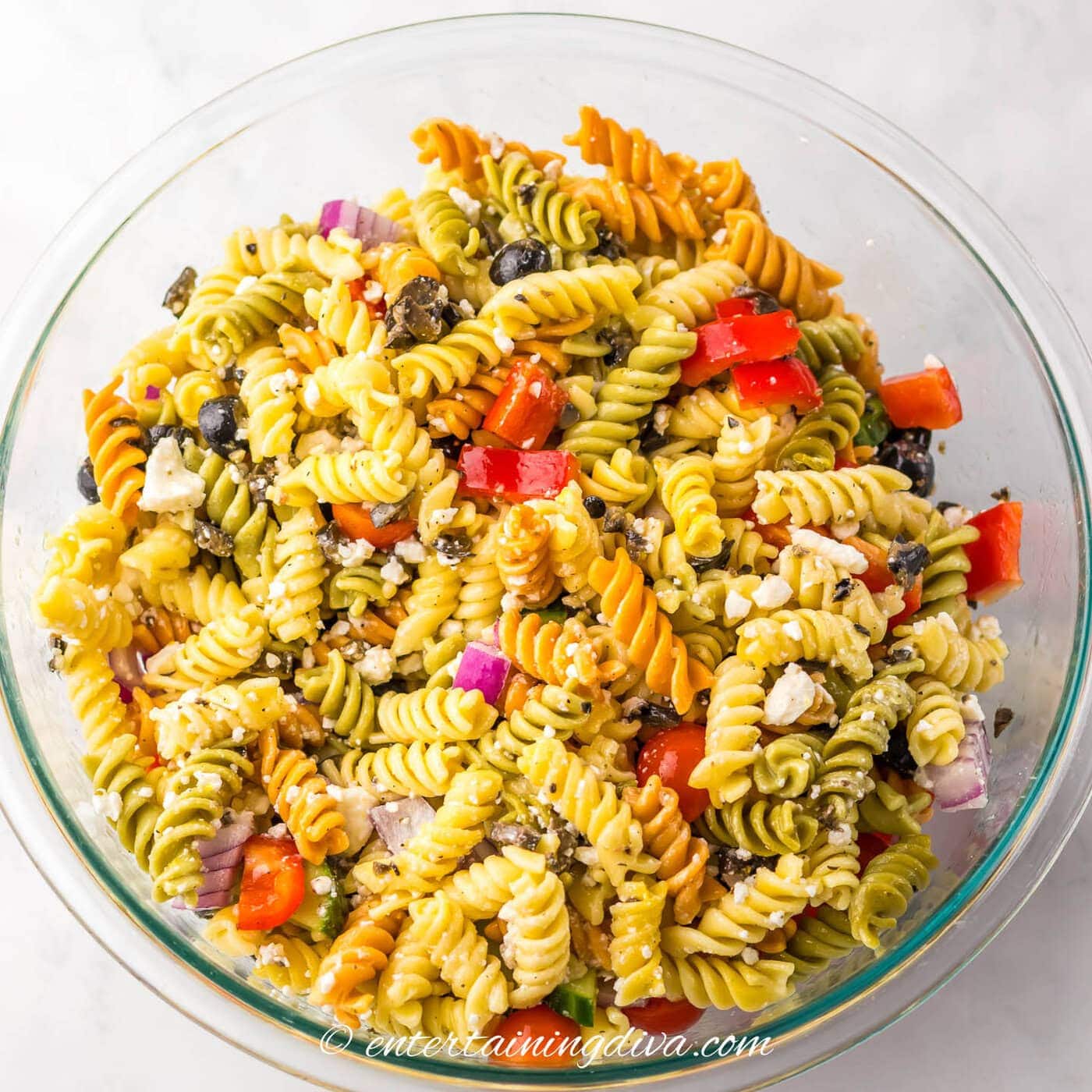 greek pasta salad in a bowl after the dressing has been added