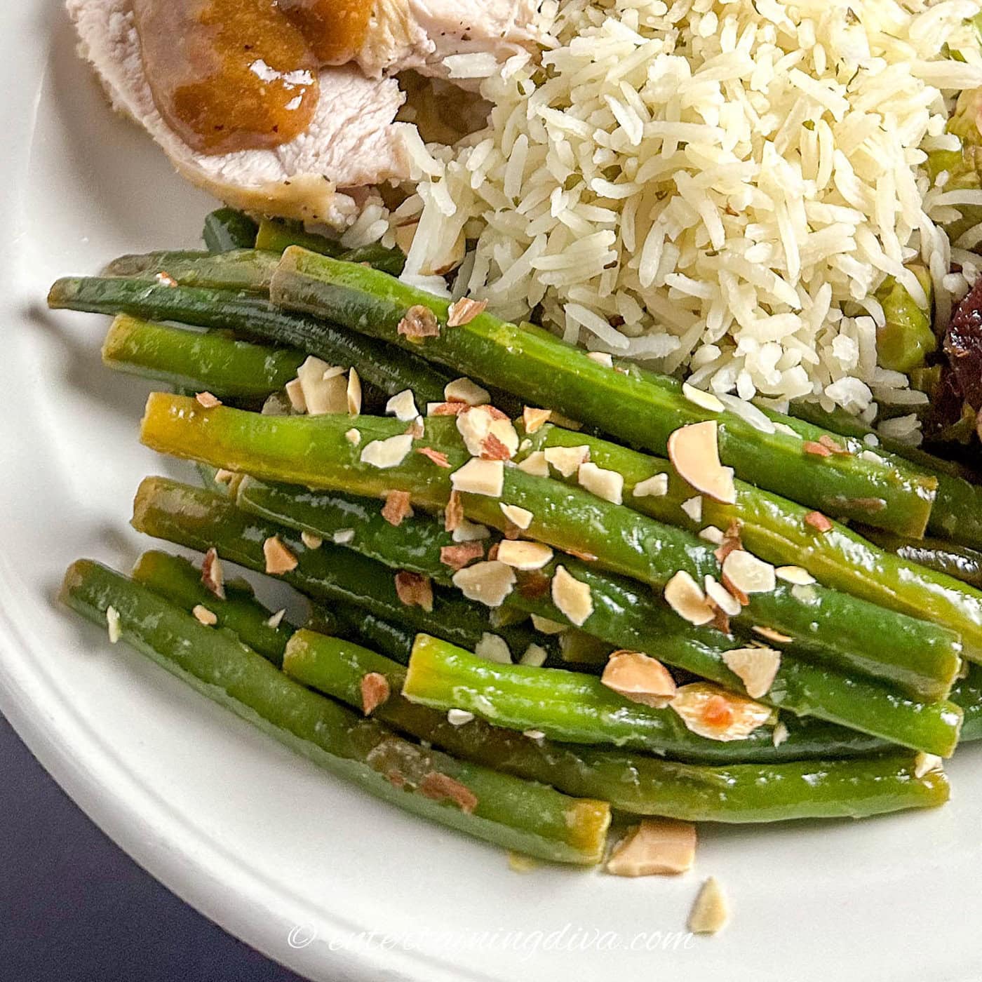 close up of green beans almondine on a plate with rice