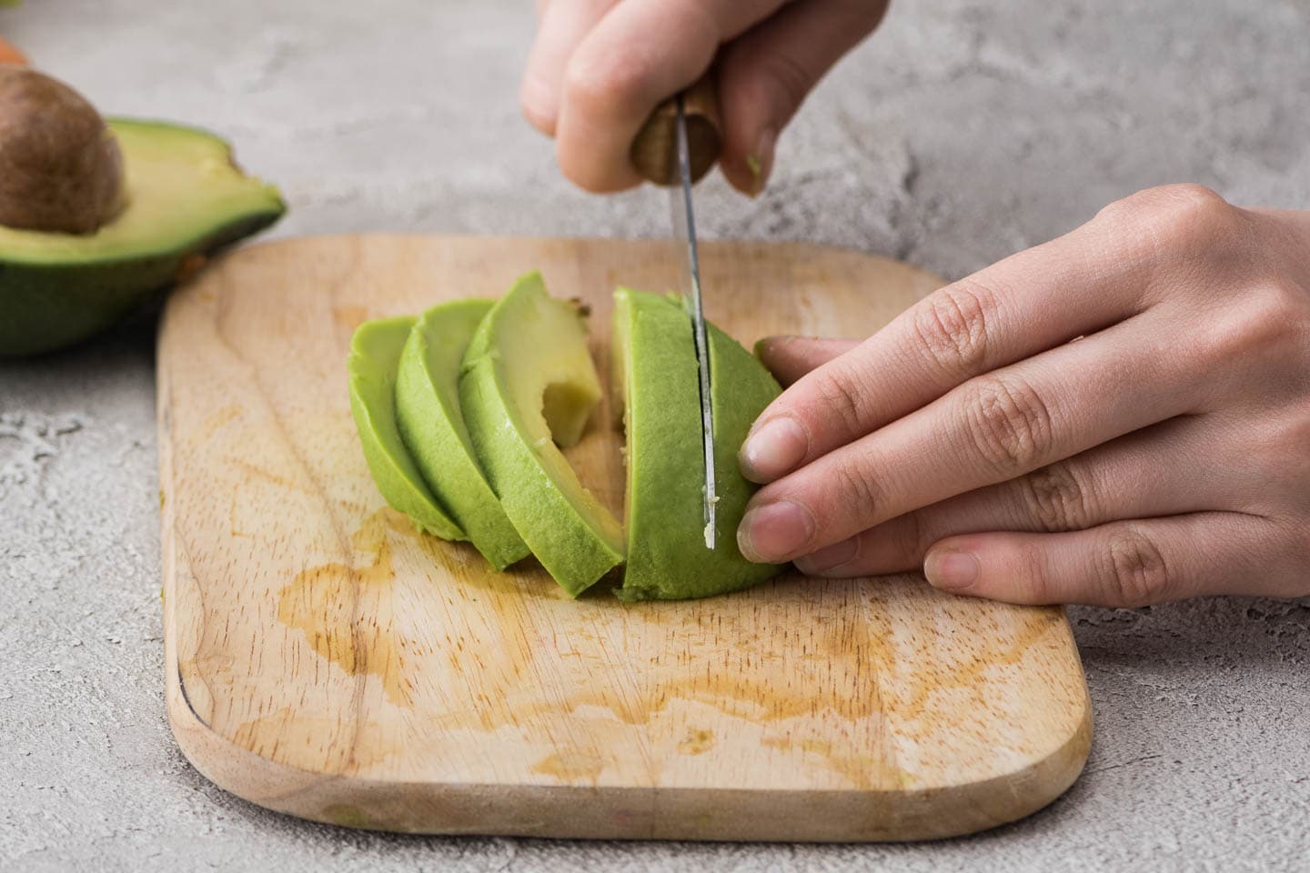 avocado being sliced on a cutting board