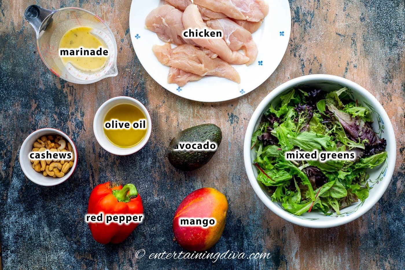 grilled chicken salad ingredients - salad greens, mango, avocado, chicken, red pepper, olive oil, marinade and cashews