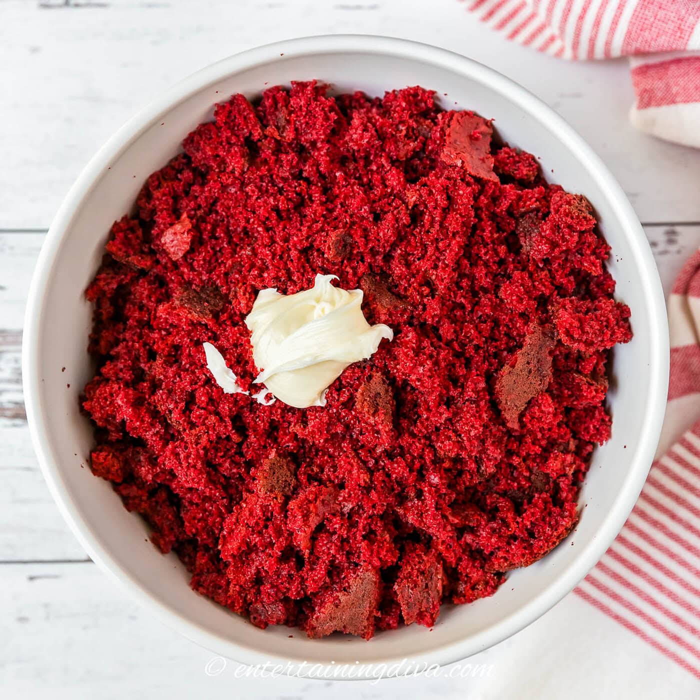 broken up red velvet cake in a bowl with cream cheese icing