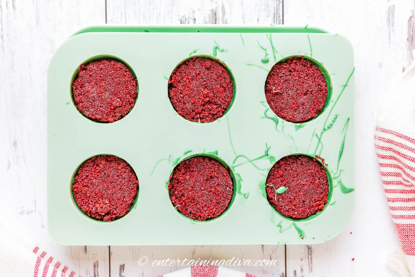 red velvet cake pucks in a mold with green chocolate