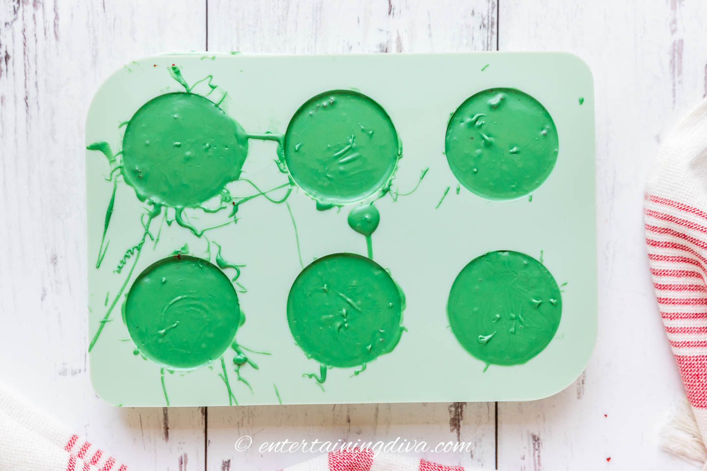 green chocolate covering cake pucks in a mold
