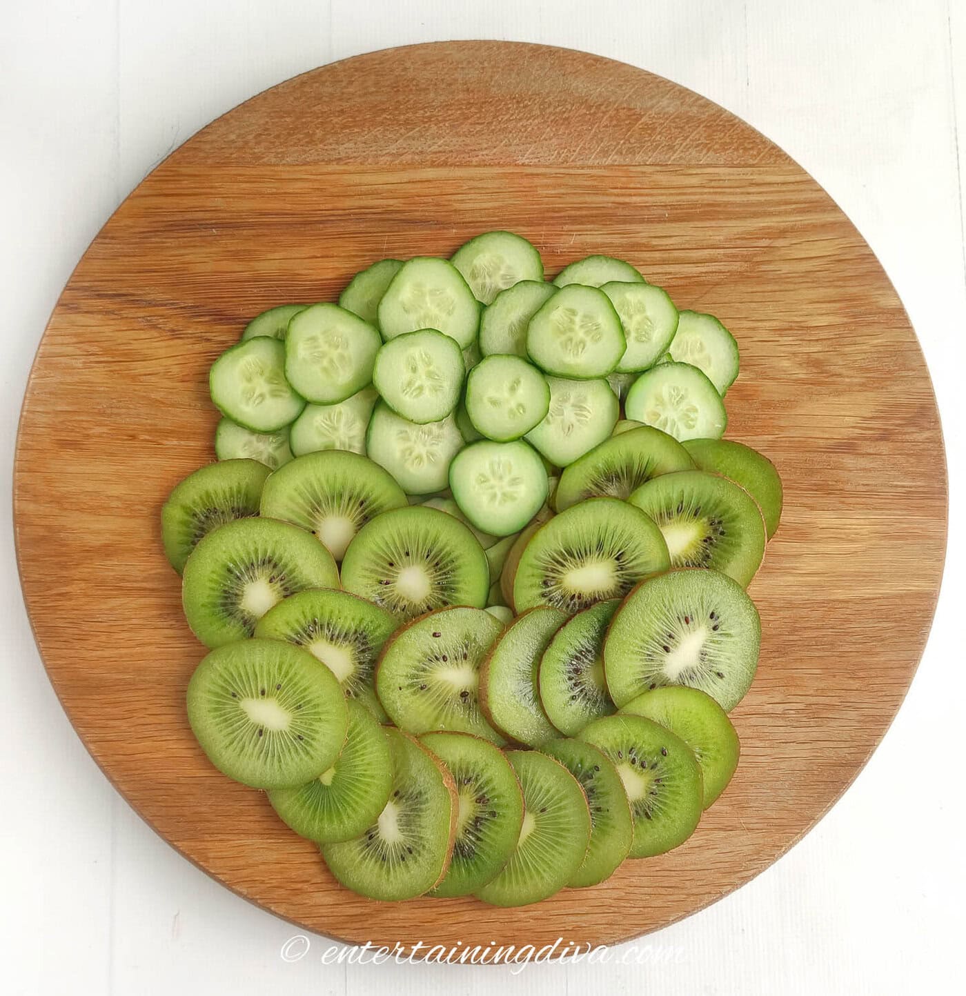 cucumber slices and kiwi slices arranged in the shape of a Grinch face