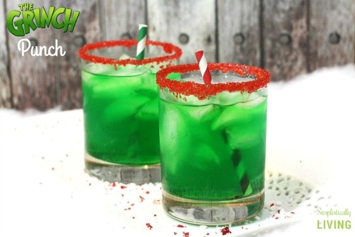 Two glasses of green punch with red striped straws.