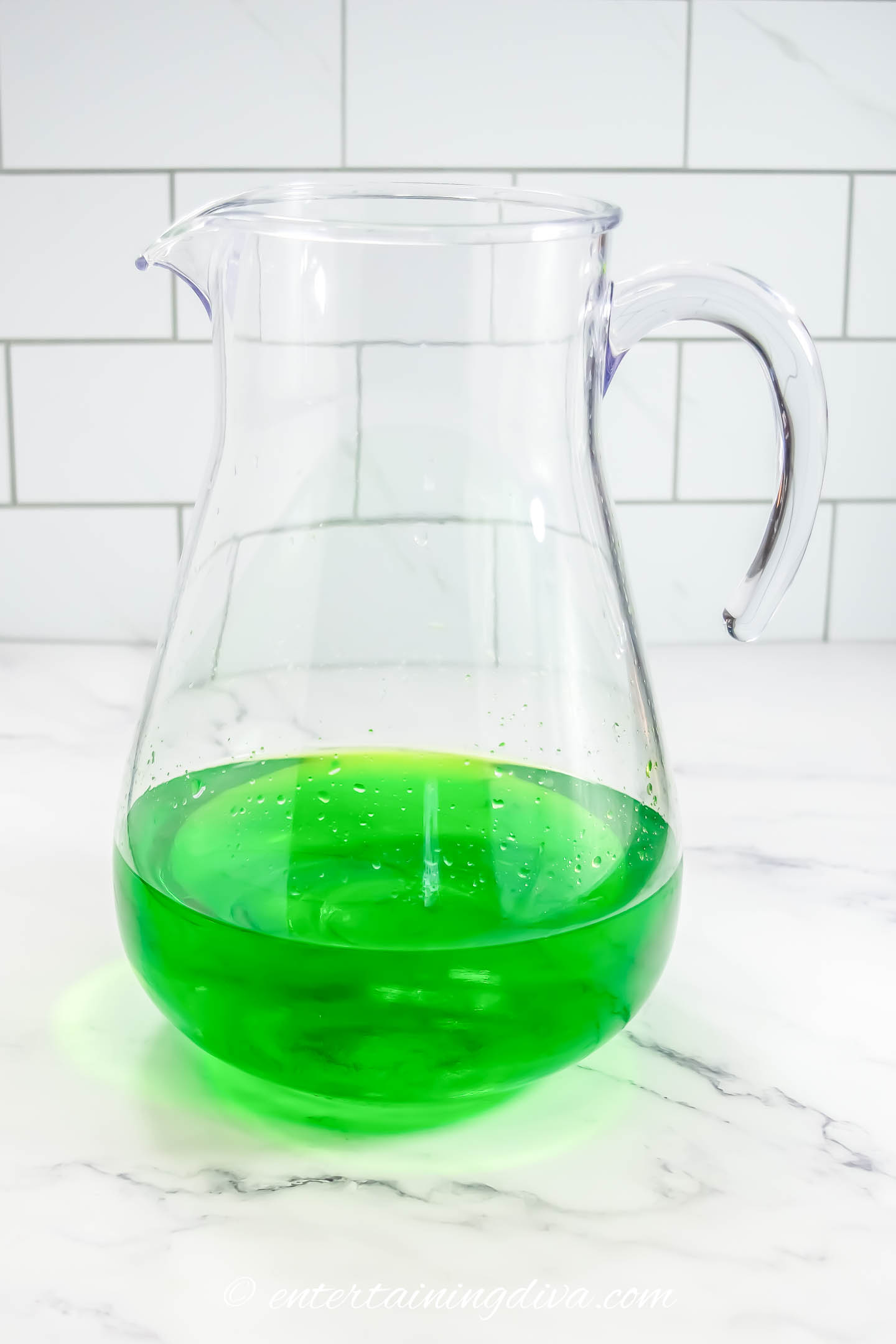 white wine, midori and pineapple juice in a pitcher