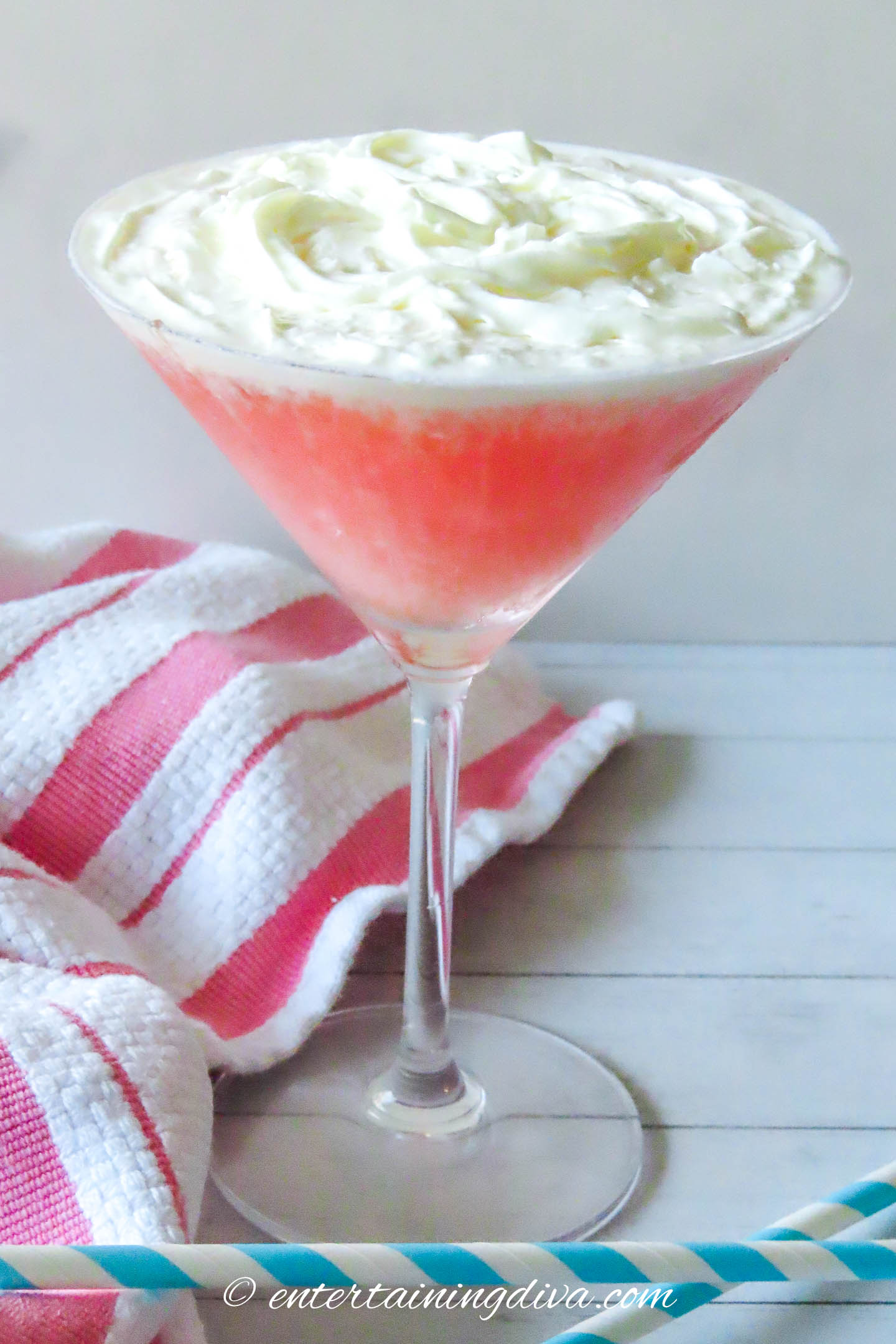 A guavatini with a red and white towel and blue and white straws