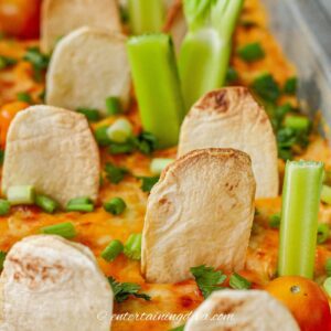 Halloween buffalo chicken dip decorated with celery "trees", tortilla gravestones and tomato "pumpkins"