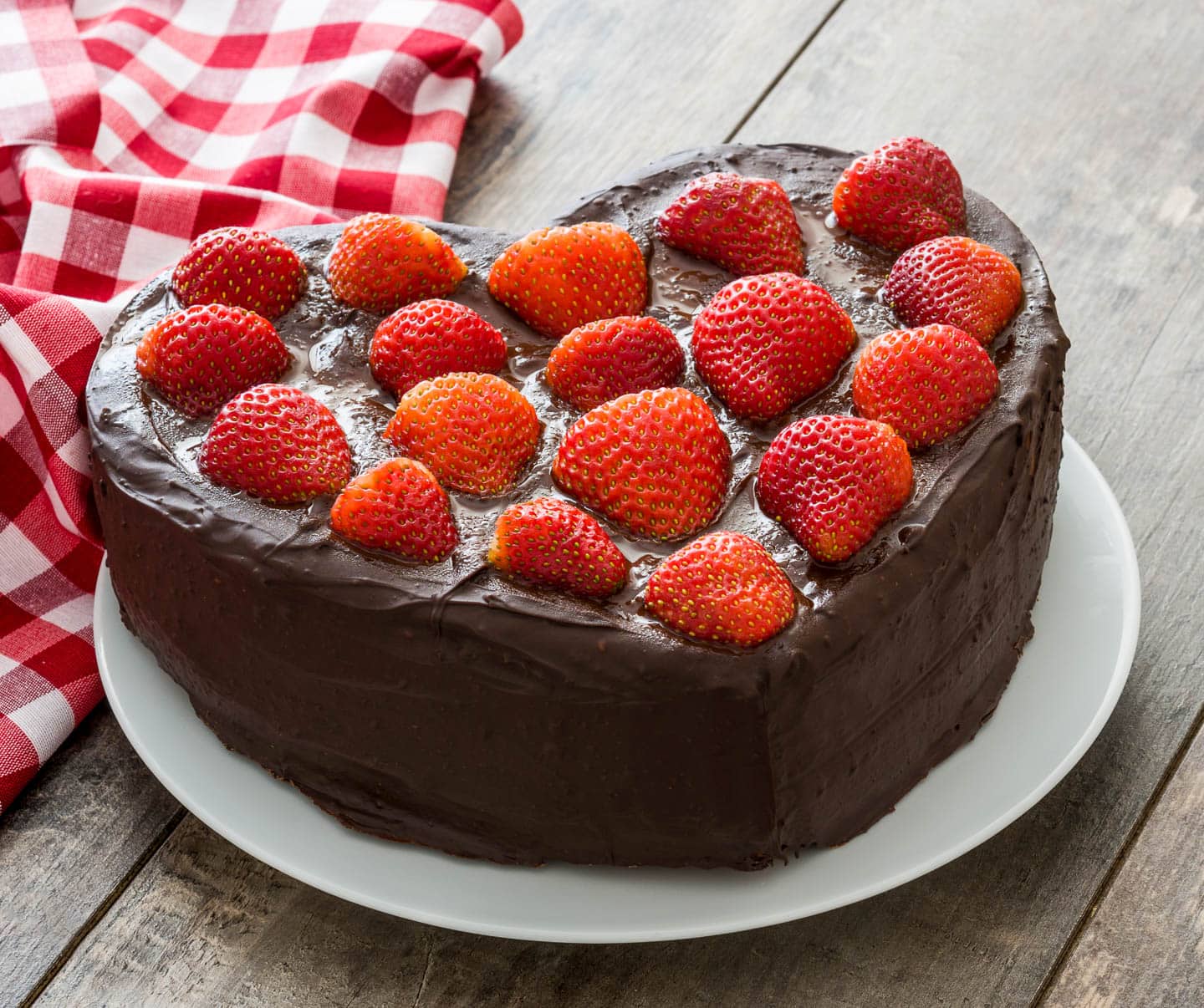 chocolate heart cake covered with strawberries