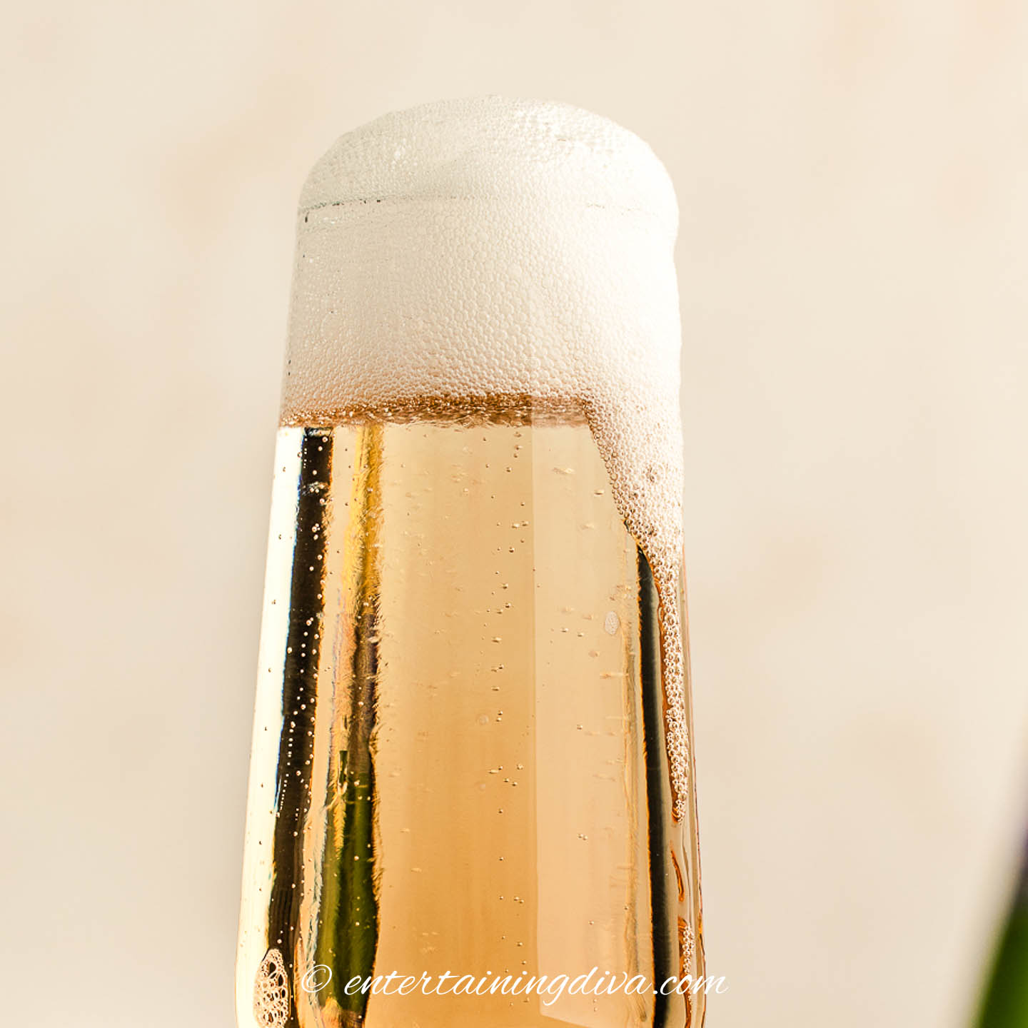 champagne foaming over the top of a champagne glass