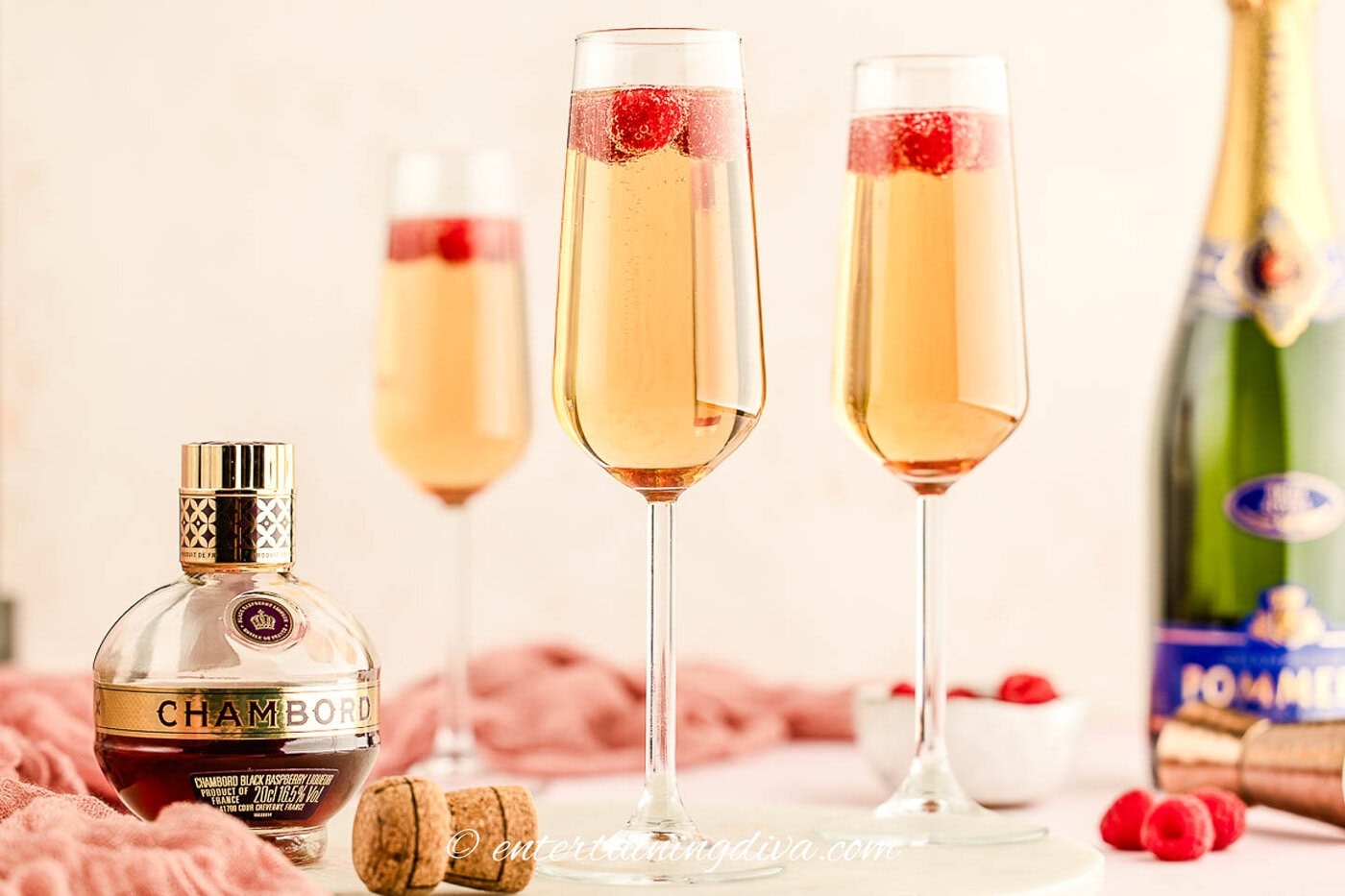 3 glasses of Kir Royale beside a bottle of chambord