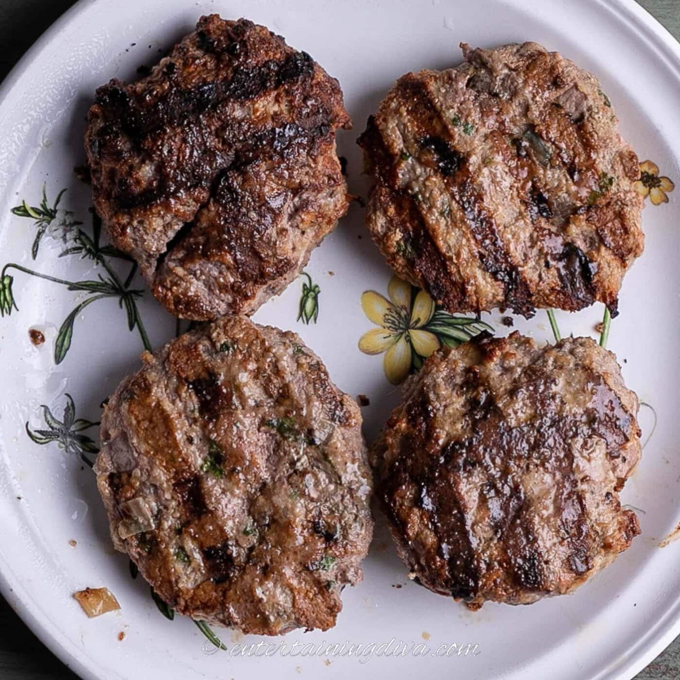 4 grilled lemon cilantro turkey burger patties on a plate