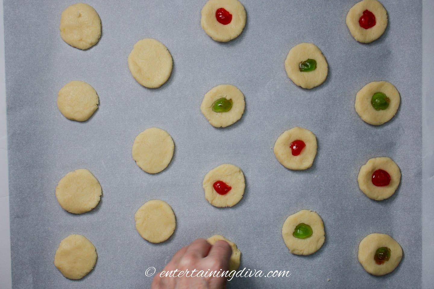 candied cherries being pressed into lemon cream cheese cookies
