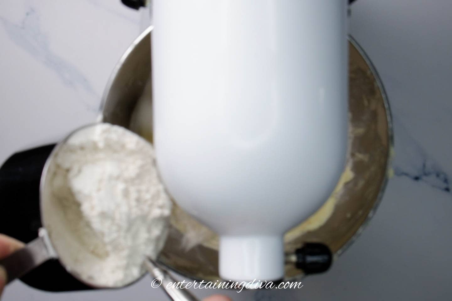 flour being added to the cookie dough in the mixer