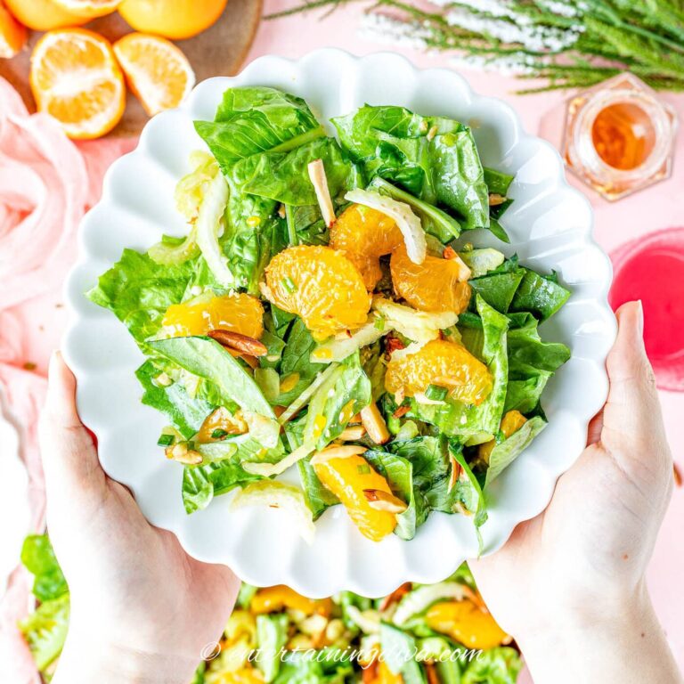 Mandarin orange romaine salad being served on a plate.