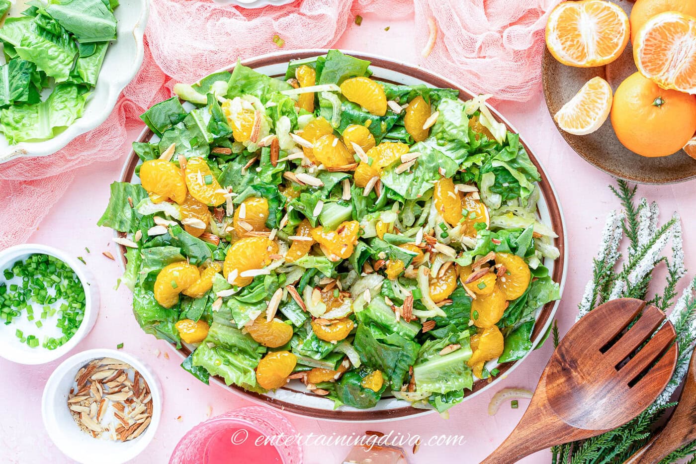 mandarin orange romaine salad in a bowl on a pink table