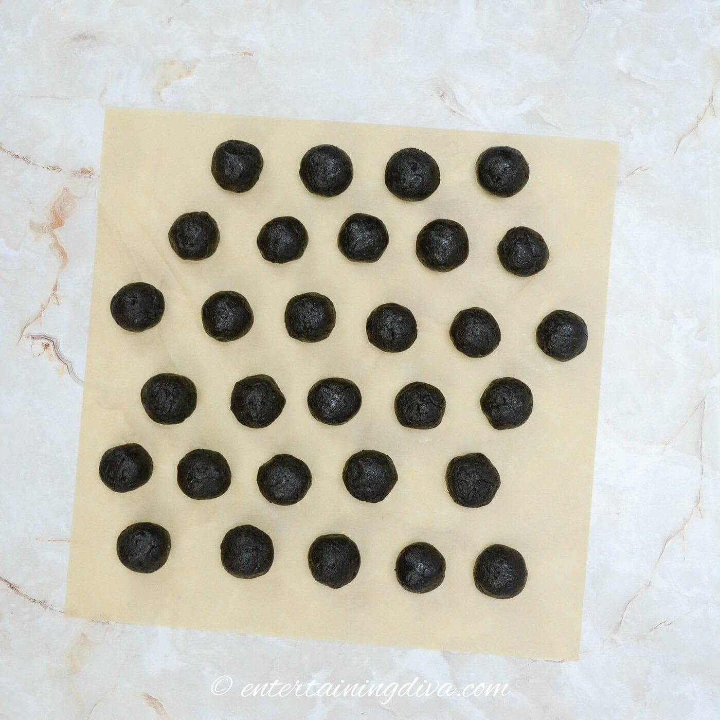 Oreo cookie filling rolled into balls on a parchment paper