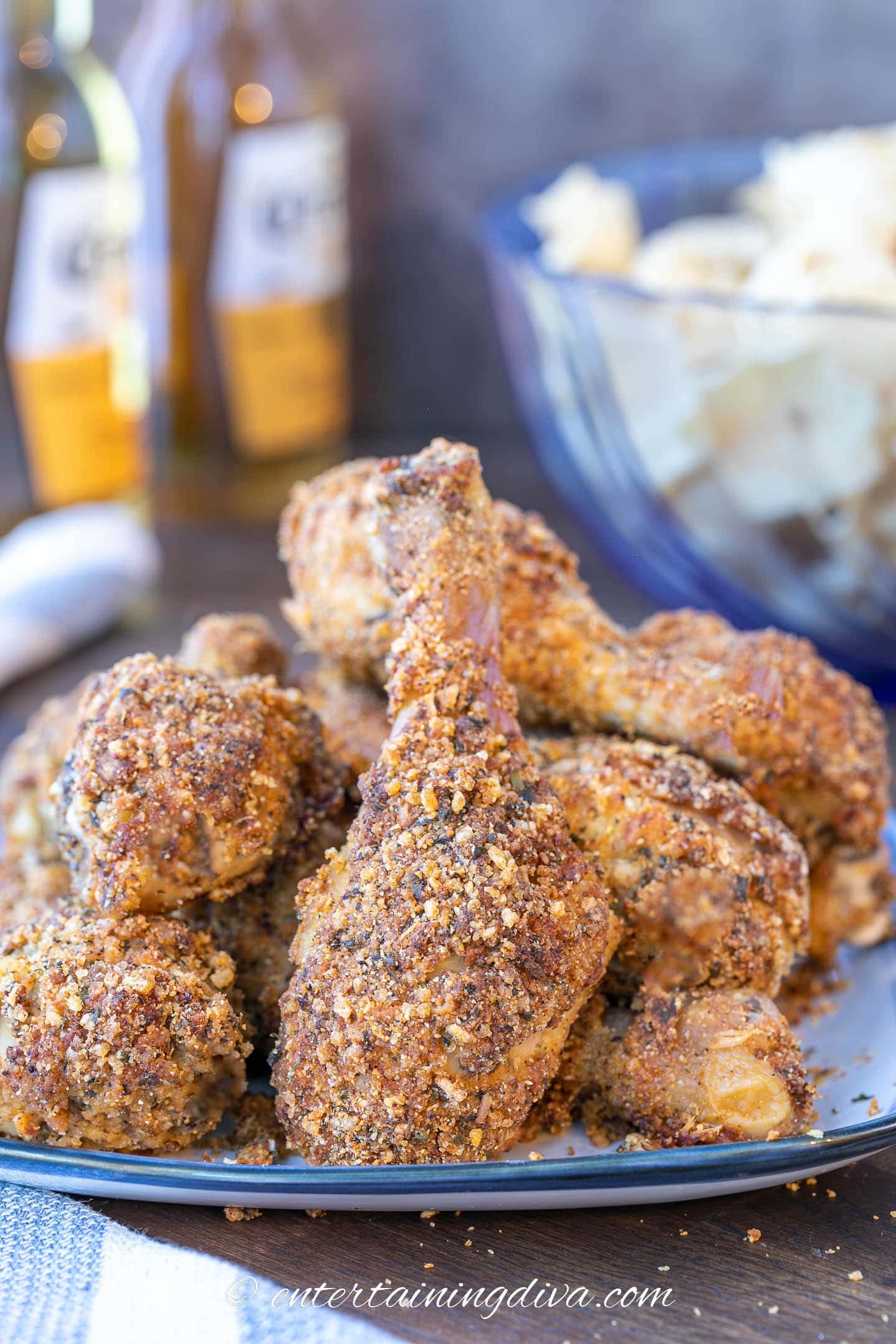 a stack of baked breaded chicken legs on a plate