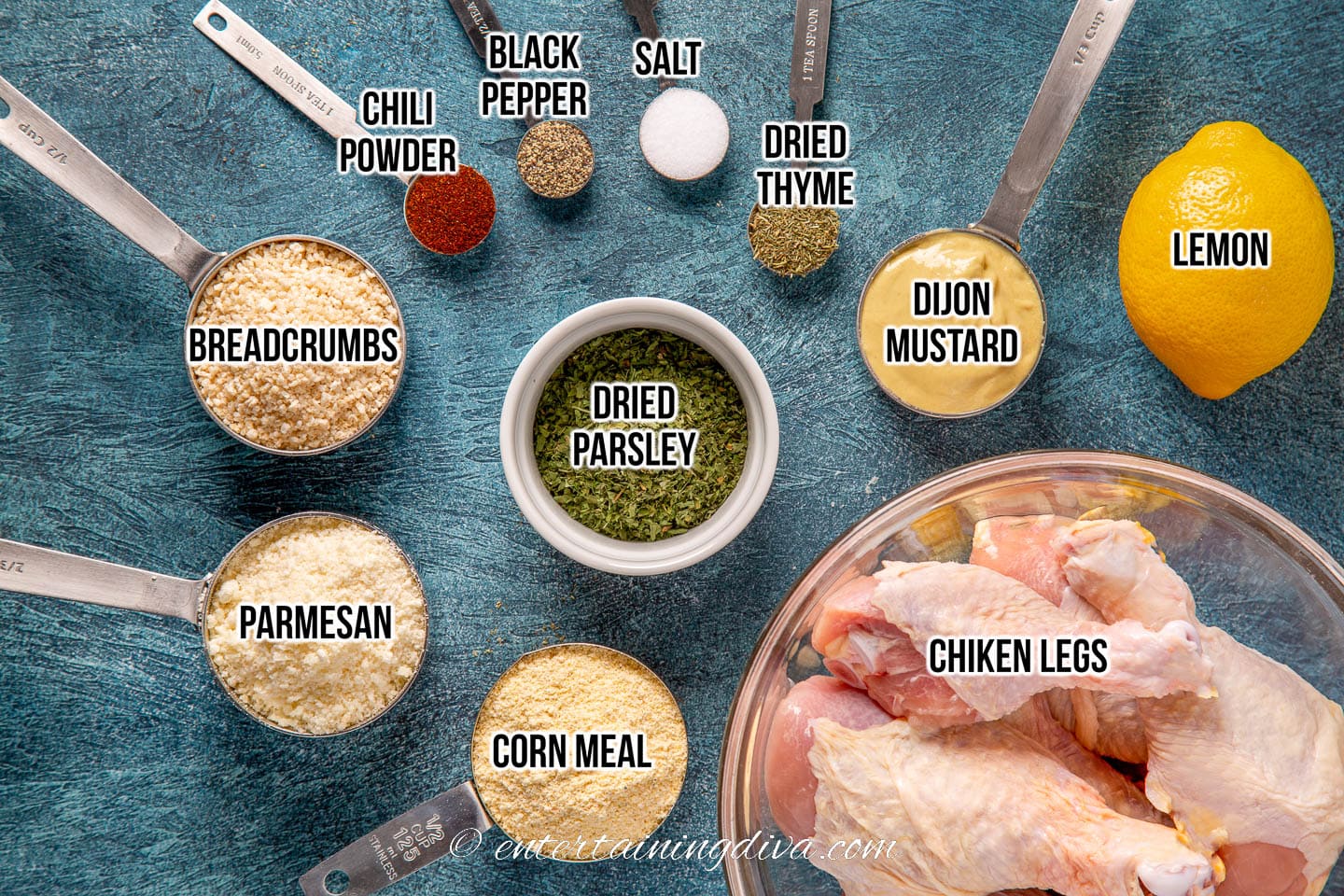 oven baked breaded chicken leg ingredients - breadcrumbs, parmesan cheese, corn meal, parsley, chili powder, black pepper salt, dried thyme, dijon mustard, lemon and chicken drumsticks