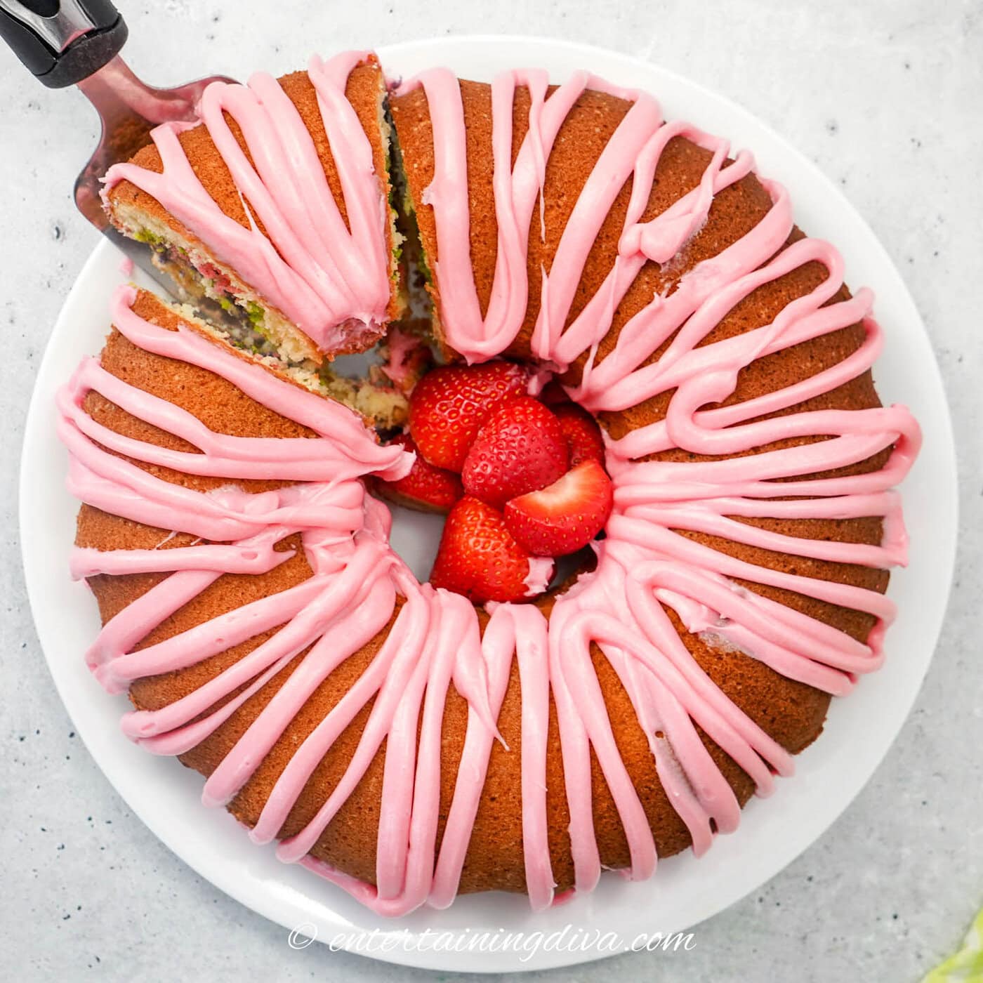 Overhead of the pastel swirled bundt cake with a slice being removed