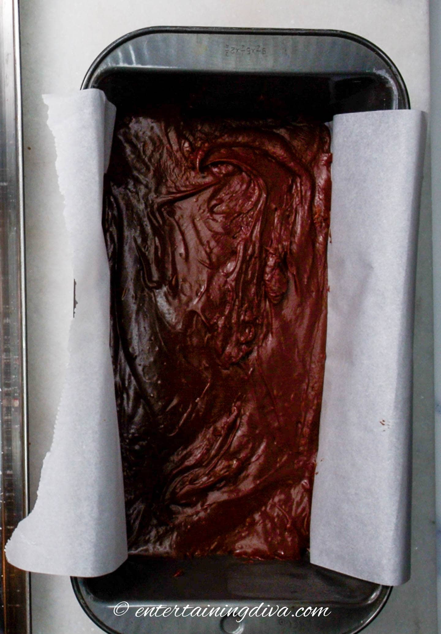 peppermint chocolate fudge in a parchment paper lined loaf pan