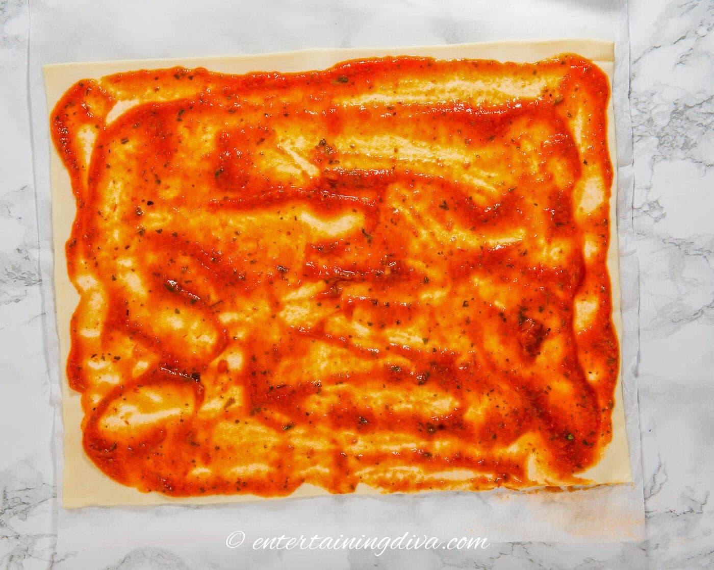 marinara sauce spread out over phyllo dough