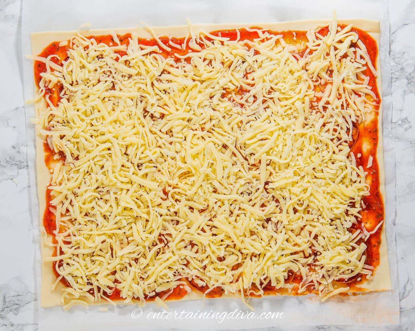 mozzarella covering pepperoni and marinara sauce on phyllo dough